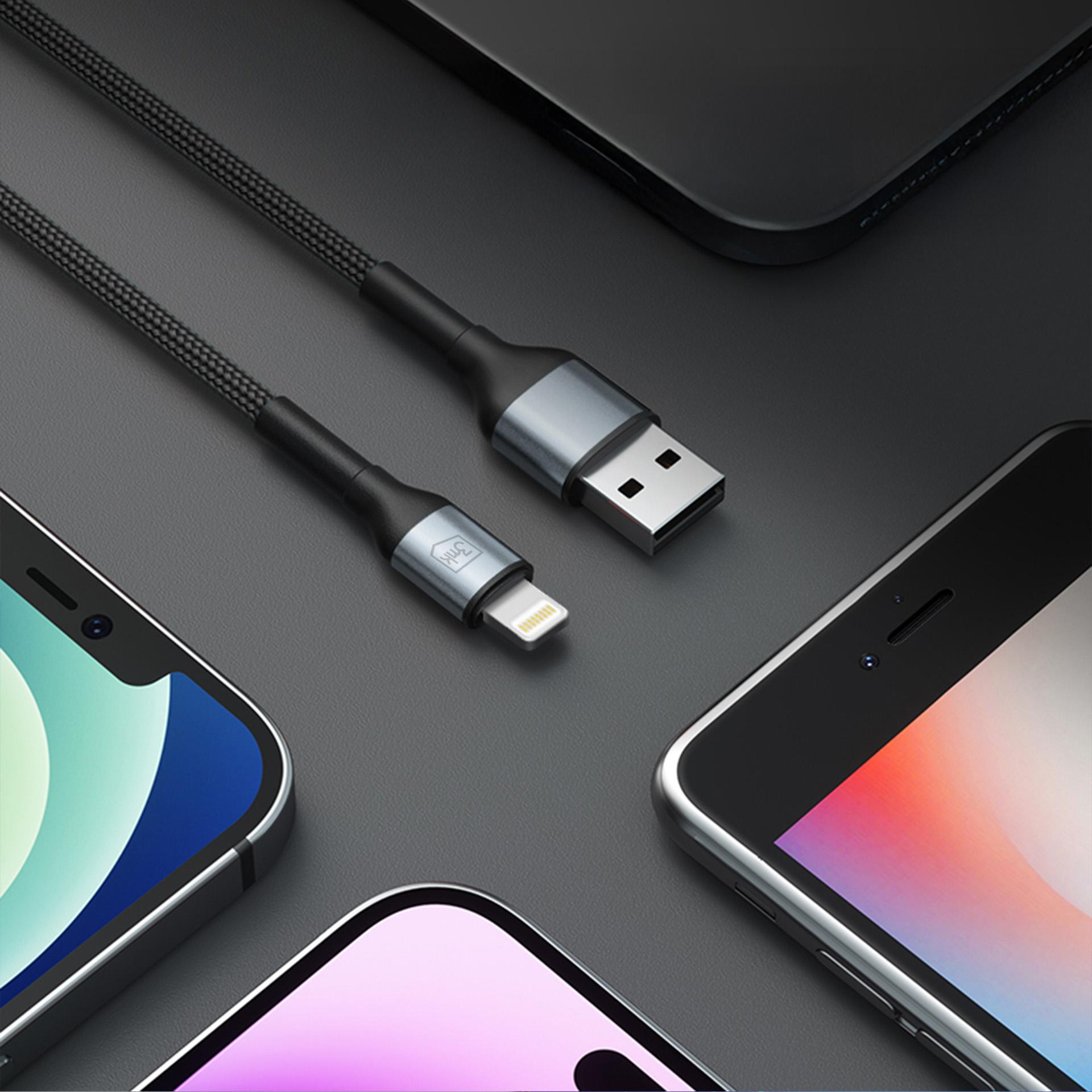 Un cavo di ricarica nero con connettori USB-A e Lightning giace su una superficie scura.