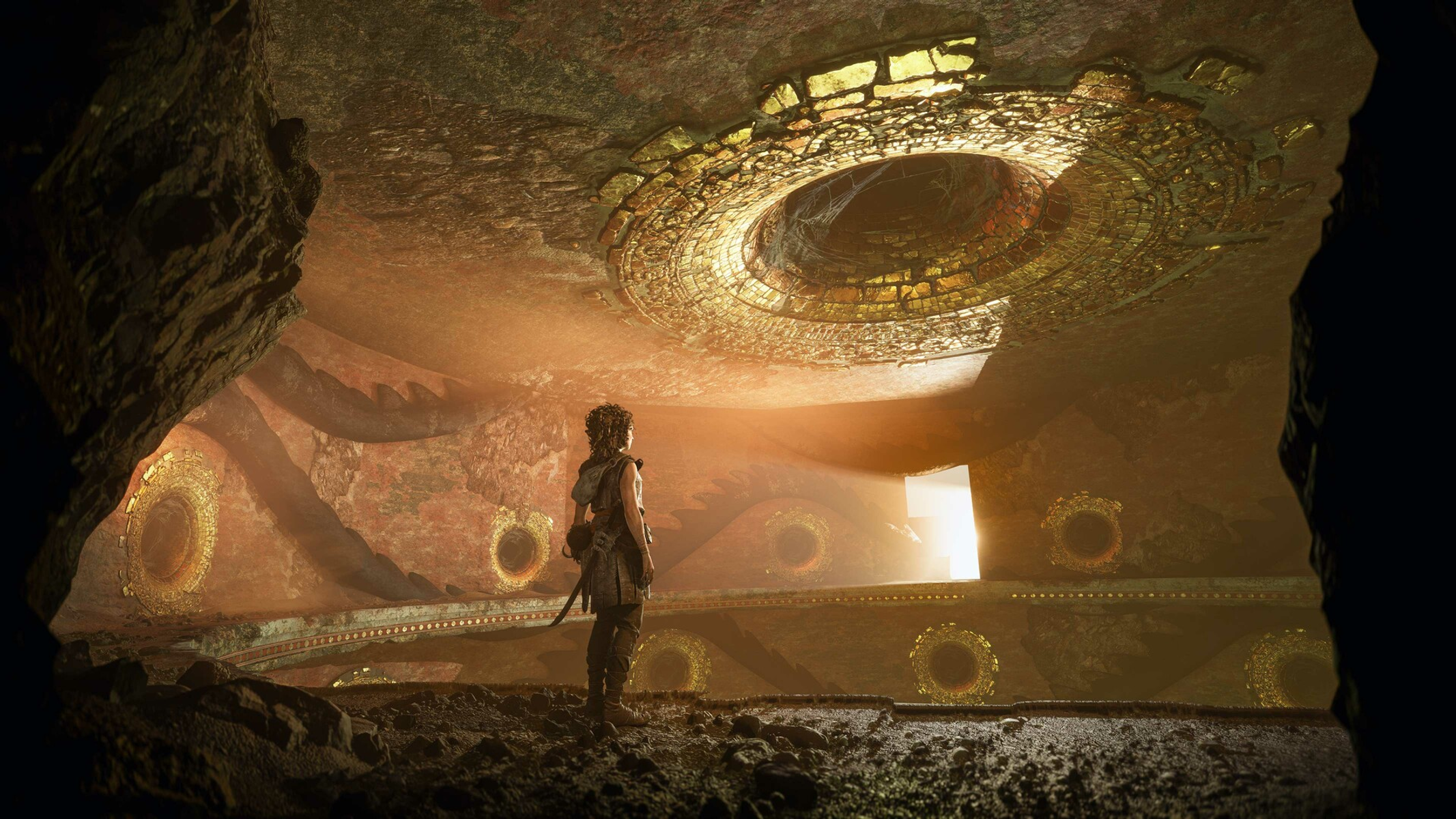 Un guerriero si erge in una caverna con ornamenti dorati circolari e una grande apertura in alto.