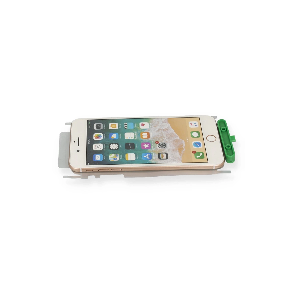 Beyaz arka plan üzerinde yeşil tutuculu altın iPhone.
