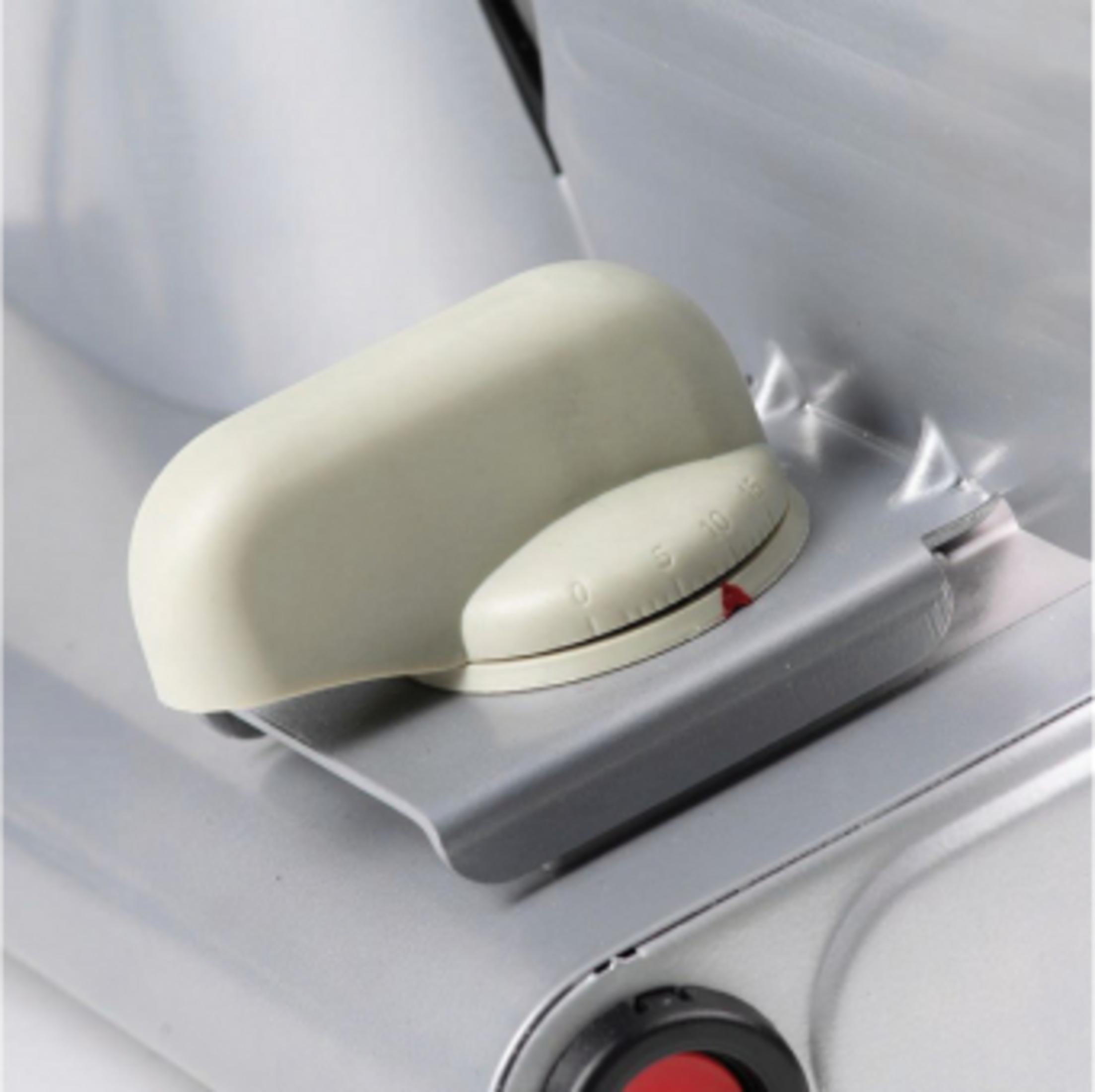 Un bouton couleur crème avec des marques d'échelle sur un chariot argenté.