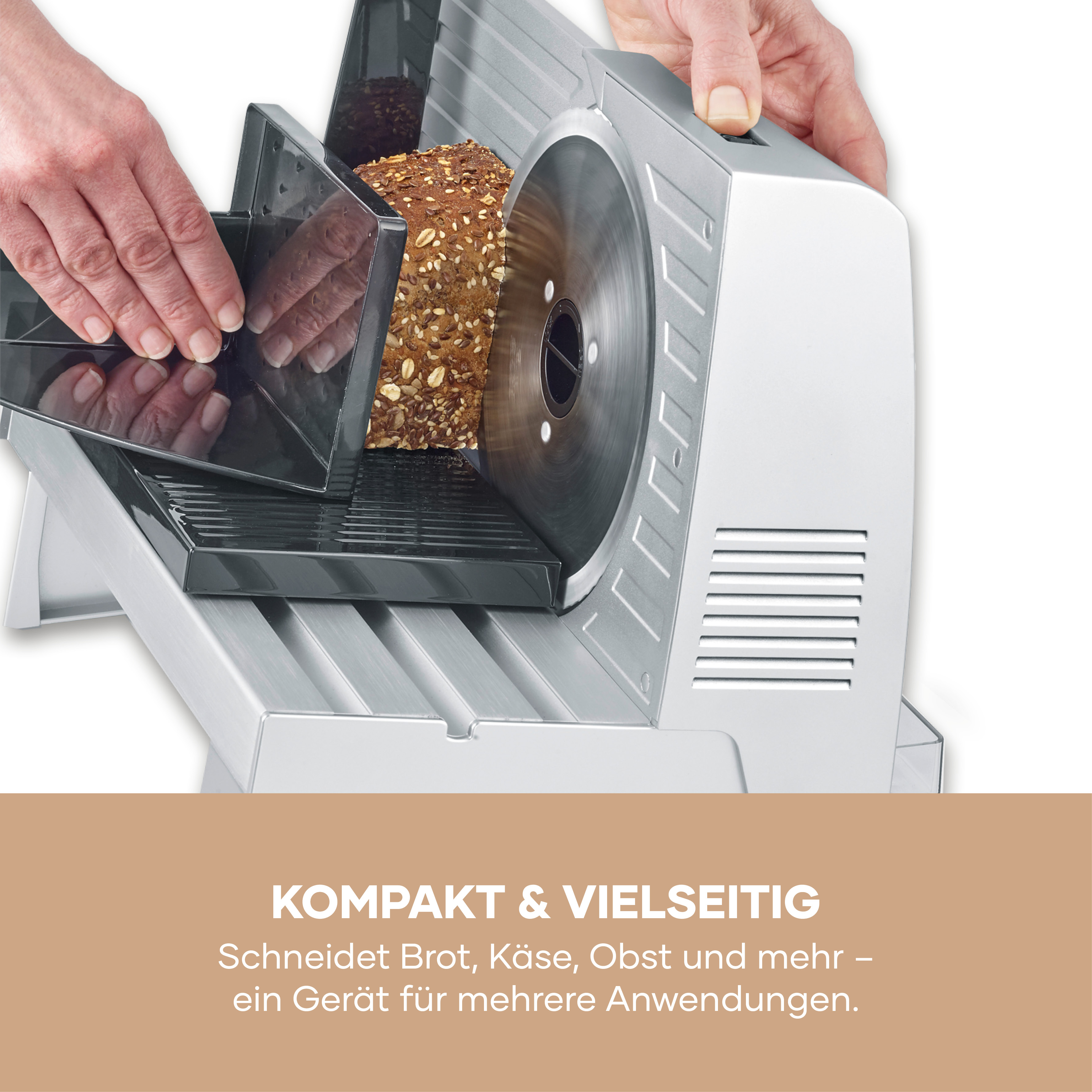 Eine Hand bedient einen Brotschneider mit einem Laib Brot.