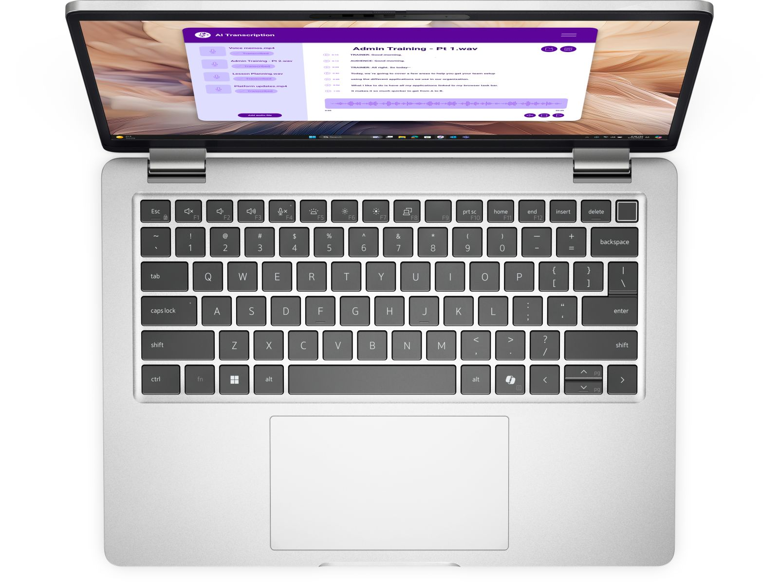 Srebrny laptop z otwartym ekranem, wyświetlający oprogramowanie do transkrypcji.