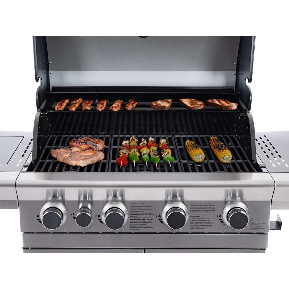 Otwarty grill z mięsem, szaszłykami warzywnymi i kolbami kukurydzy na ruszcie.