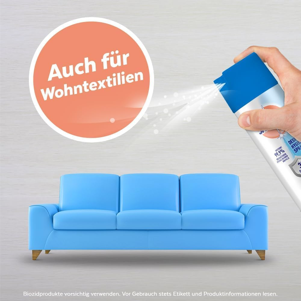 Hand sprüht Desinfektionsspray auf ein blaues Sofa. Text: Auch für Wohntextilien.