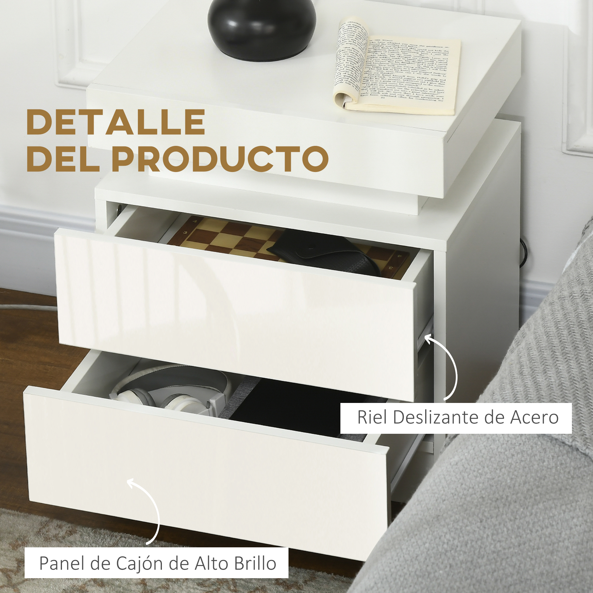 Mesita de noche blanca con cajones abiertos, tablero de ajedrez, audífonos y libro.