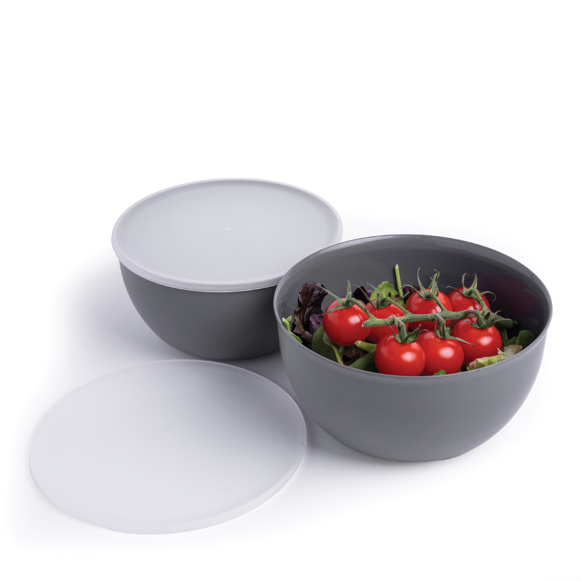Graue Schüssel mit Salat und Tomaten, daneben eine Schüssel mit Deckel.