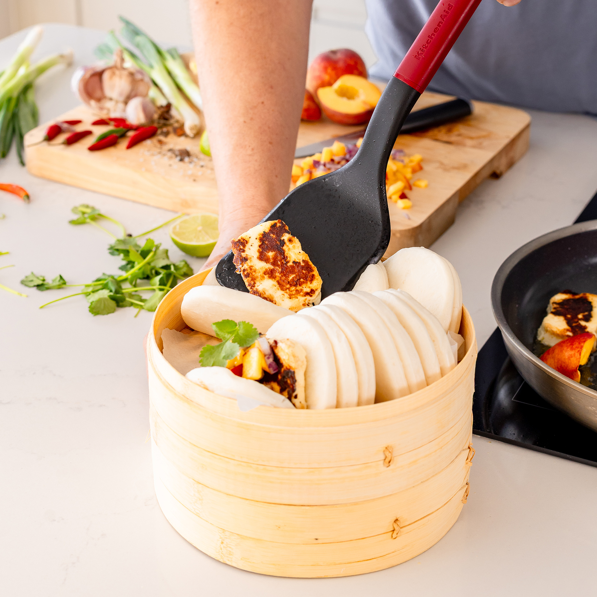 Gegrillter Halloumi wird mit gedämpften Brötchen in einem Bambusdämpfer serviert.