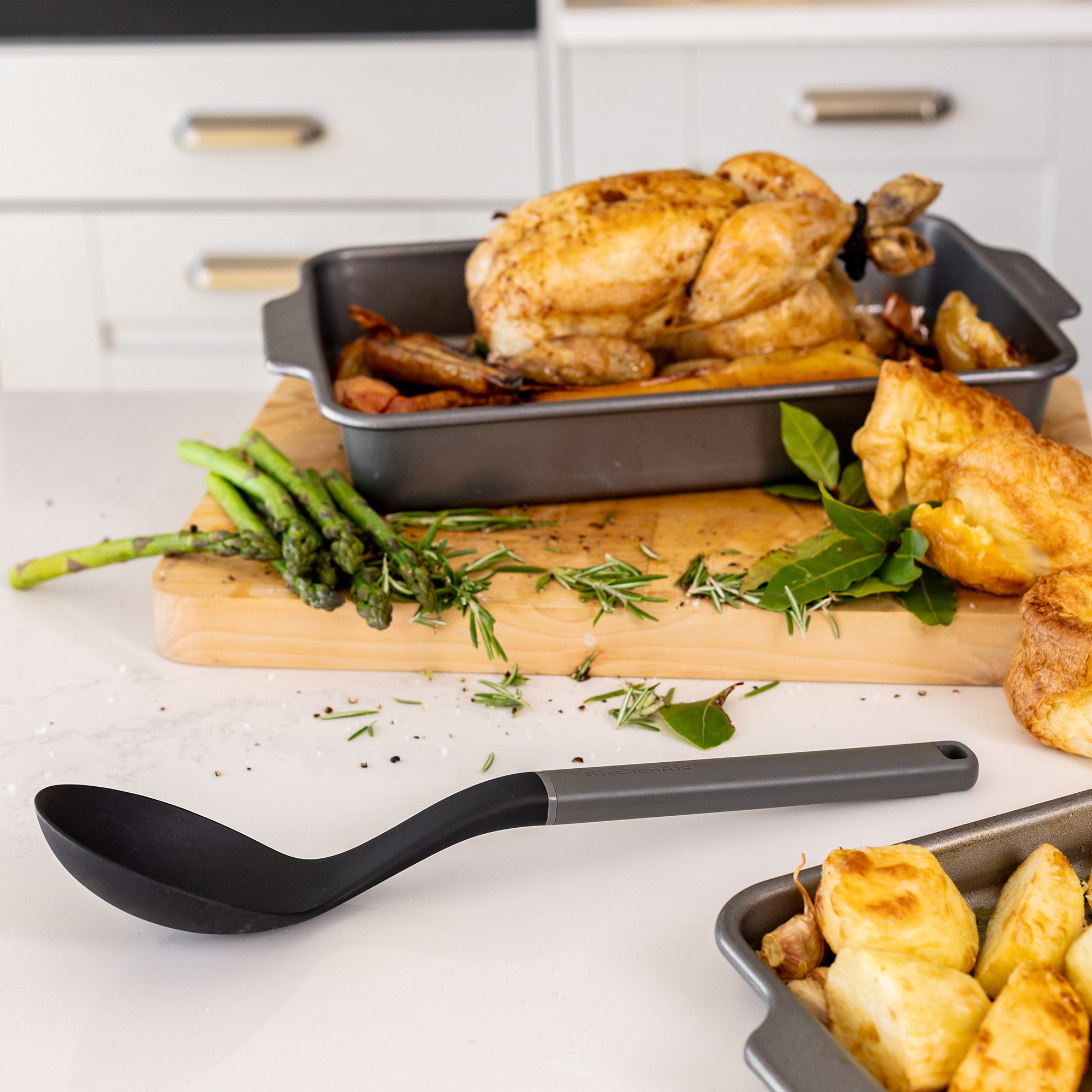 Ein gebratenes Huhn mit Beilagen wie Kartoffeln, Spargel und Yorkshire Pudding.