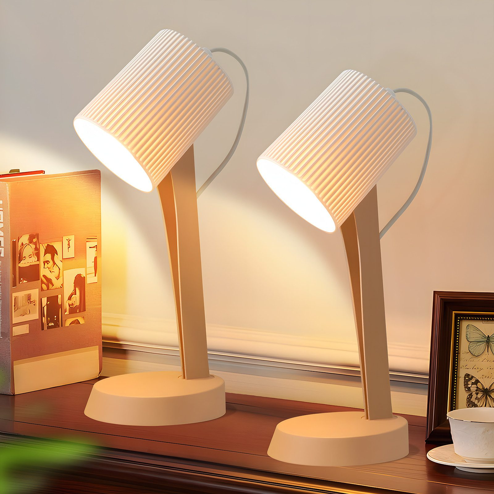 Due lampade da scrivania bianche con paralumi a coste su un mobile in legno scuro.
