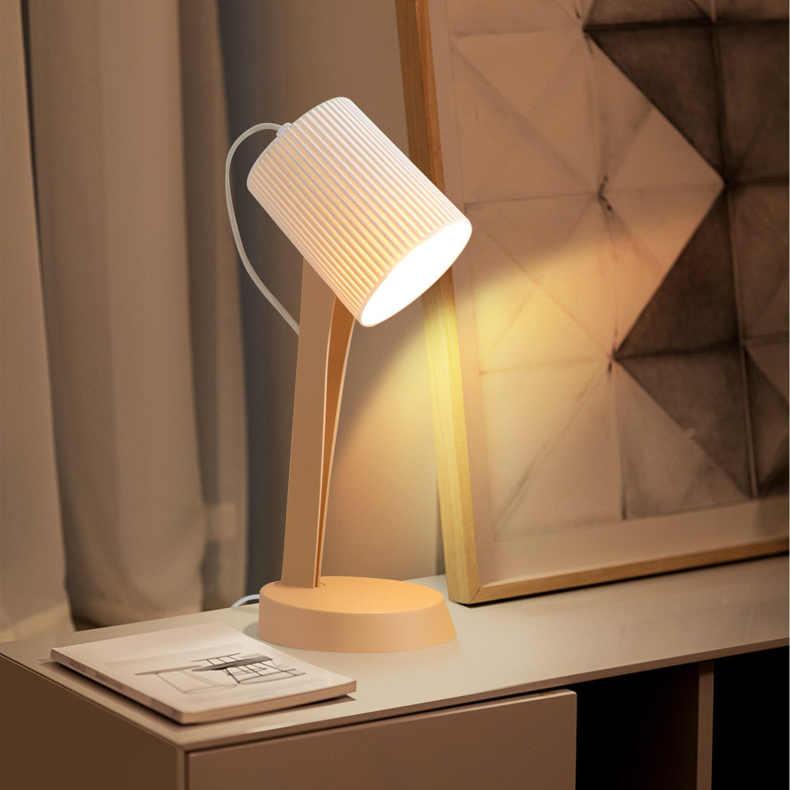 Una lampada da scrivania bianca con paralume a coste illumina un comodino.