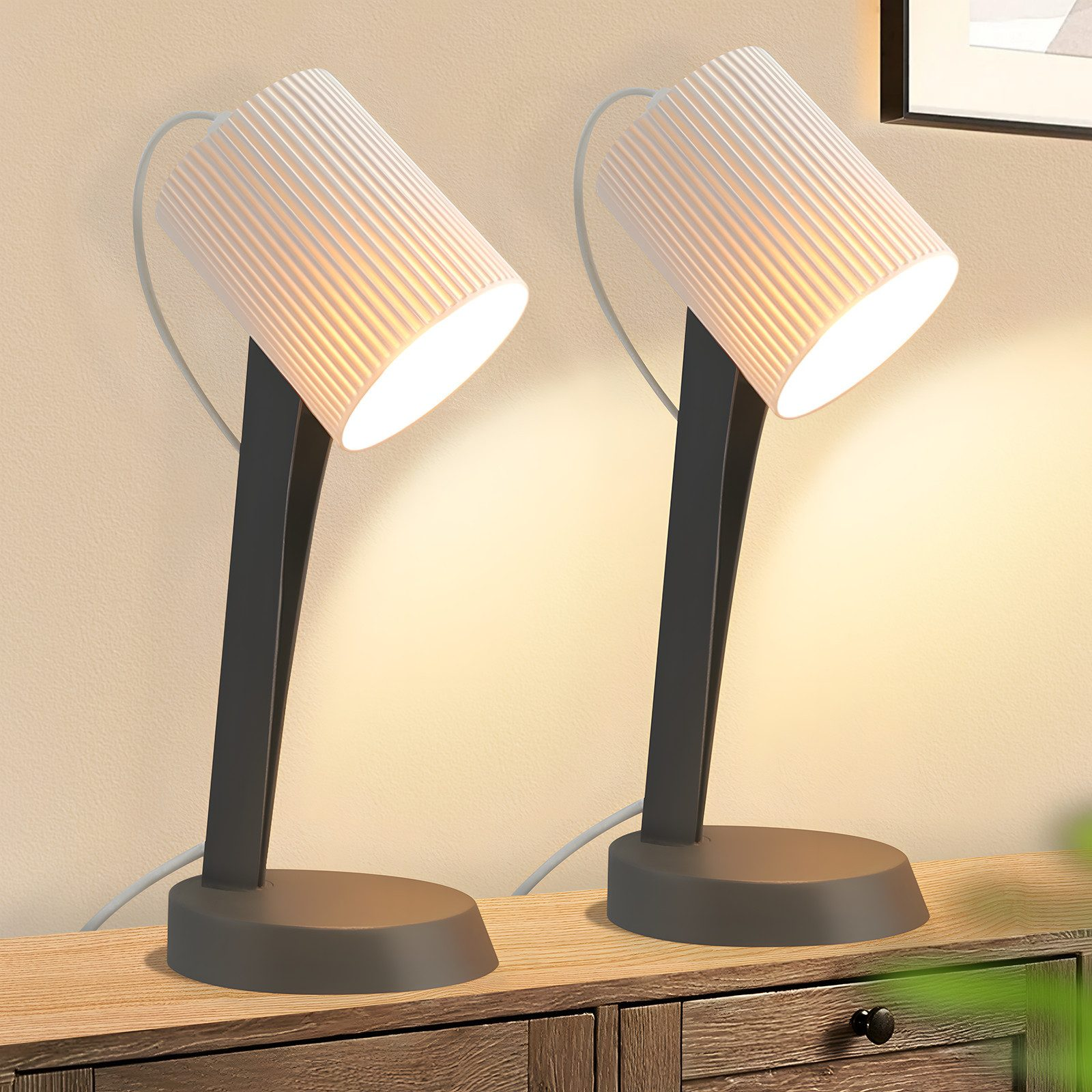 Due lampade da scrivania moderne con paralumi bianchi a coste su un mobile in legno.