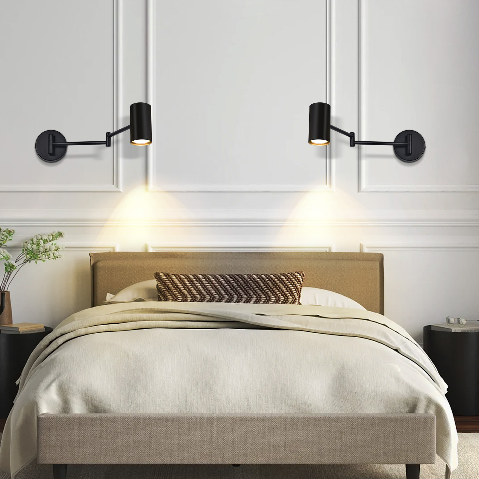 Dos apliques negros sobre una cama con ropa de cama beige y un cojín estampado.