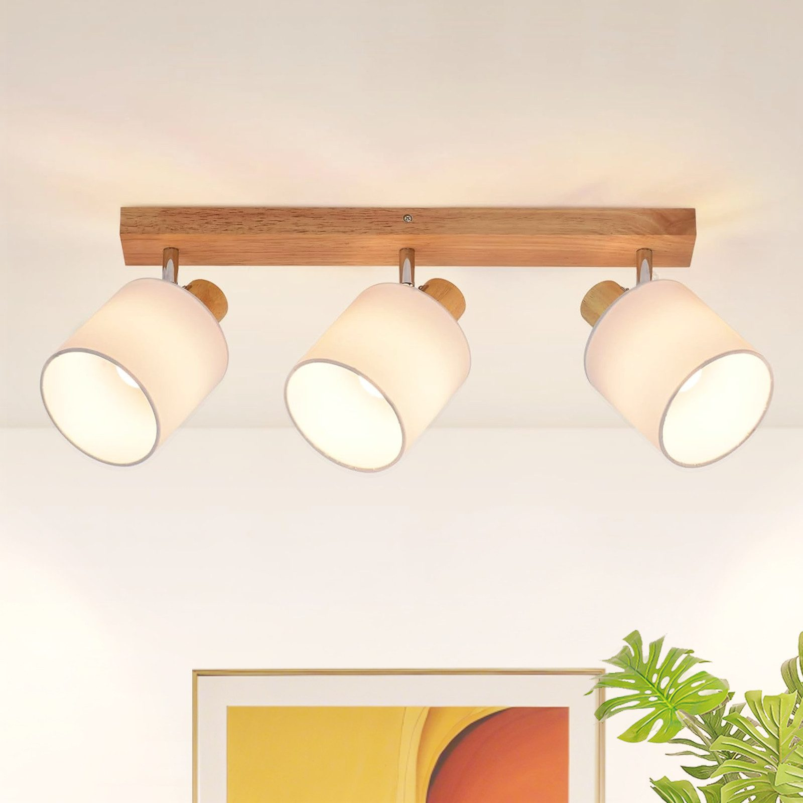 Lampadario in legno con tre paralumi bianchi e accenti in legno.