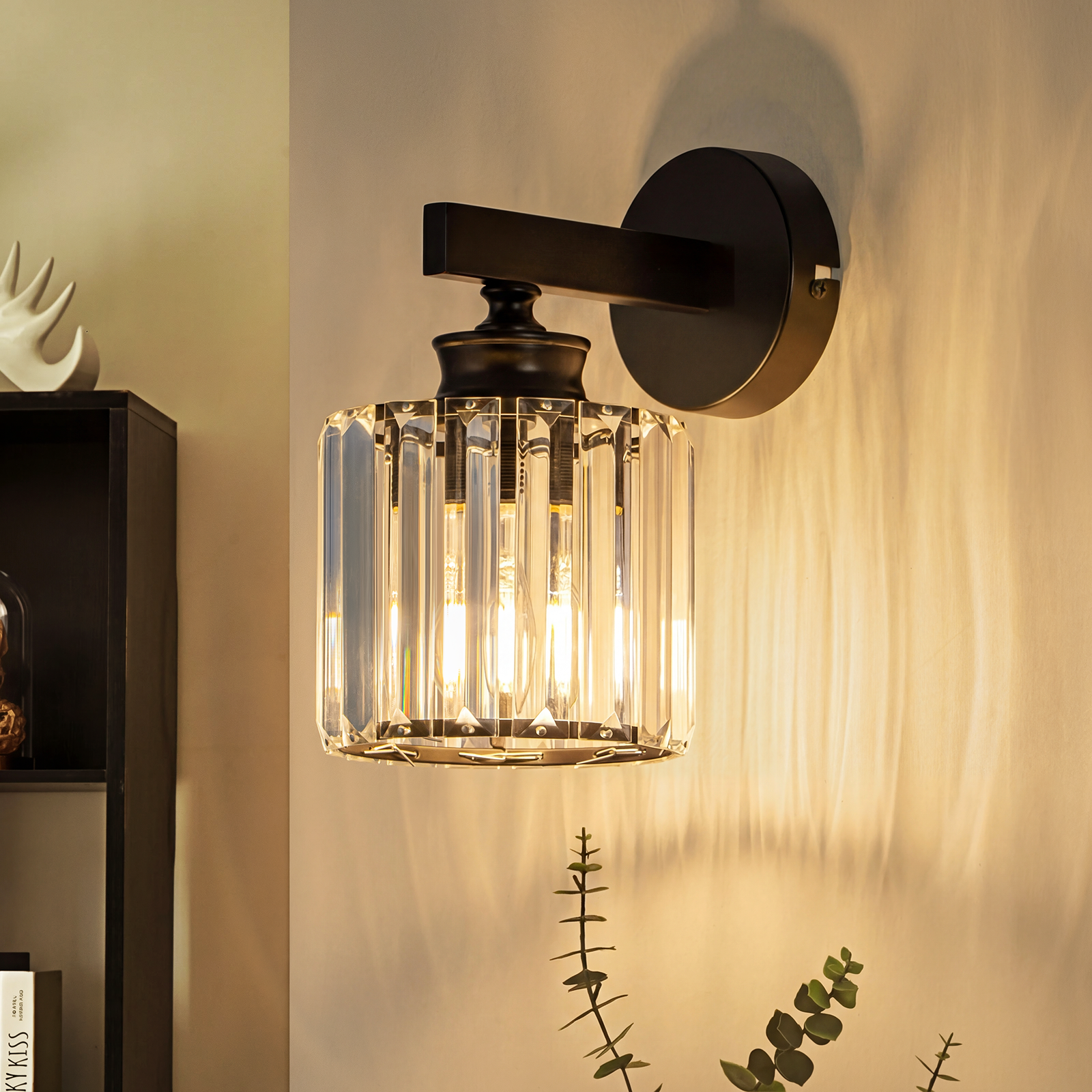 Una lámpara de pared negra con pantalla de cristal y bombillas expuestas proyecta luz.