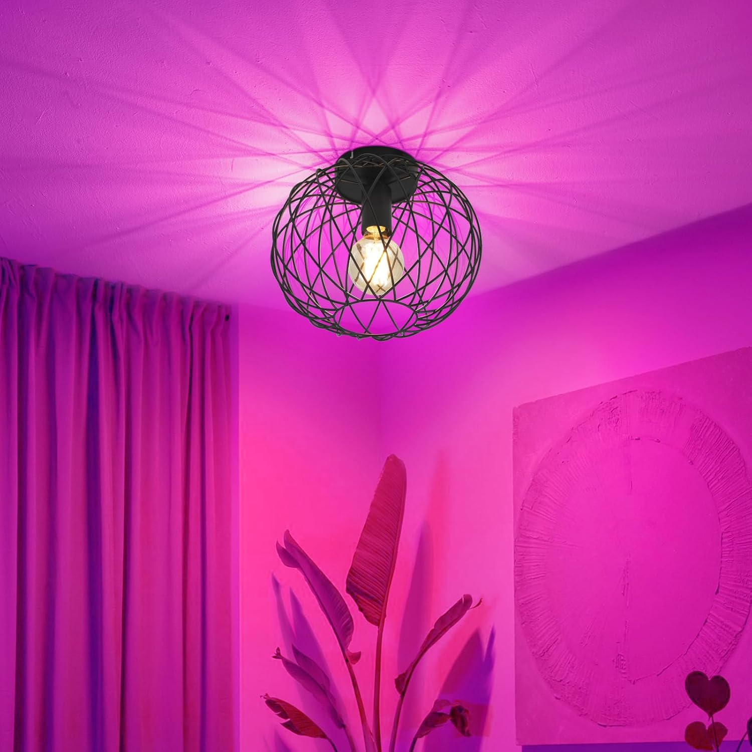 Lampada da soffitto con gabbia in filo metallico proietta motivi. Stanza rosa con tenda.