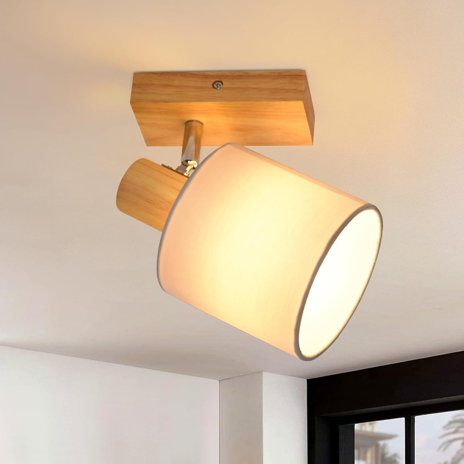 Una moderna lampada da soffitto con base in legno e paralume cilindrico bianco.