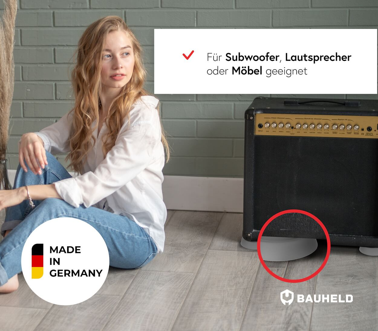 Junge Frau sitzt neben einem Gitarrenverstärker, der auf Füßen steht.