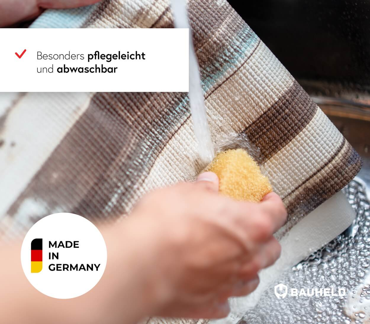 Ein Tuch wird mit einem Schwamm unter fließendem Wasser geschrubbt.
