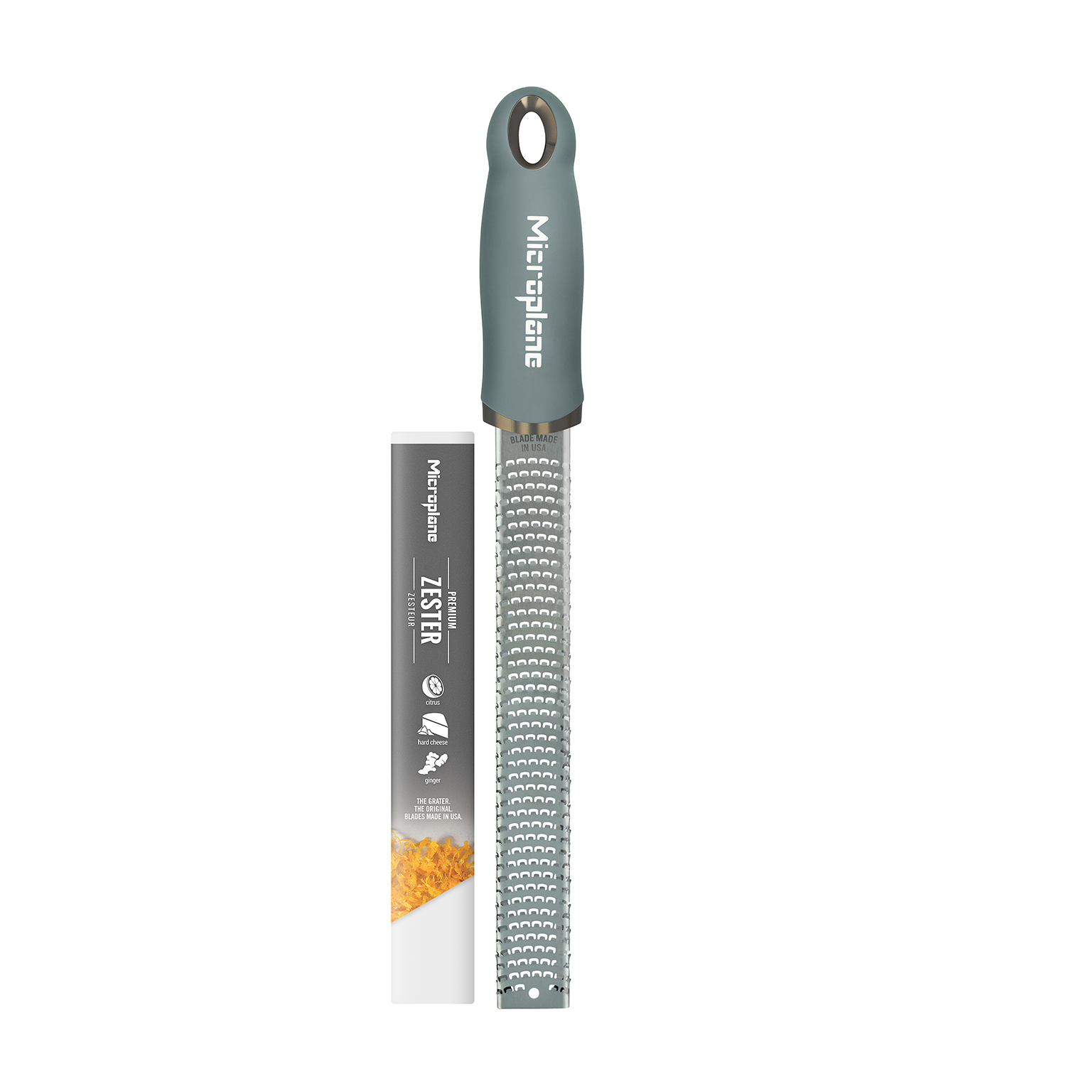 Ein grauer Microplane Zester mit Schutzkappe und Etikett mit Zitrusfrüchten, Hartkäse und Ingwer.
