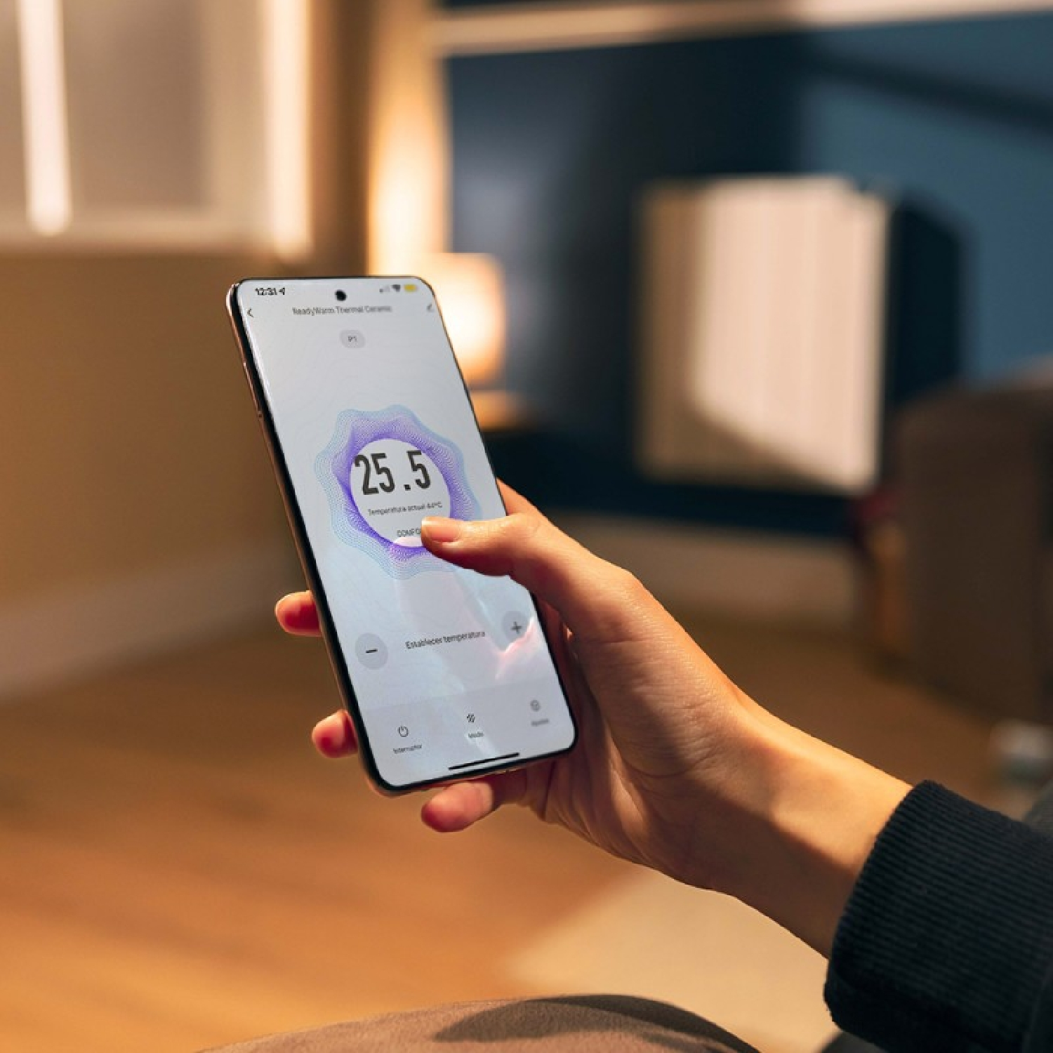 Mano che tiene smartphone con app controllo riscaldamento, mostra 25,5 gradi.
