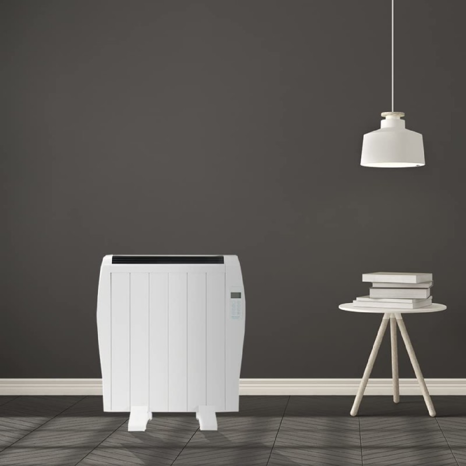Biały grzejnik stoi na drewnianej podłodze przy ciemnej ścianie. Obok mały stolik z książkami.