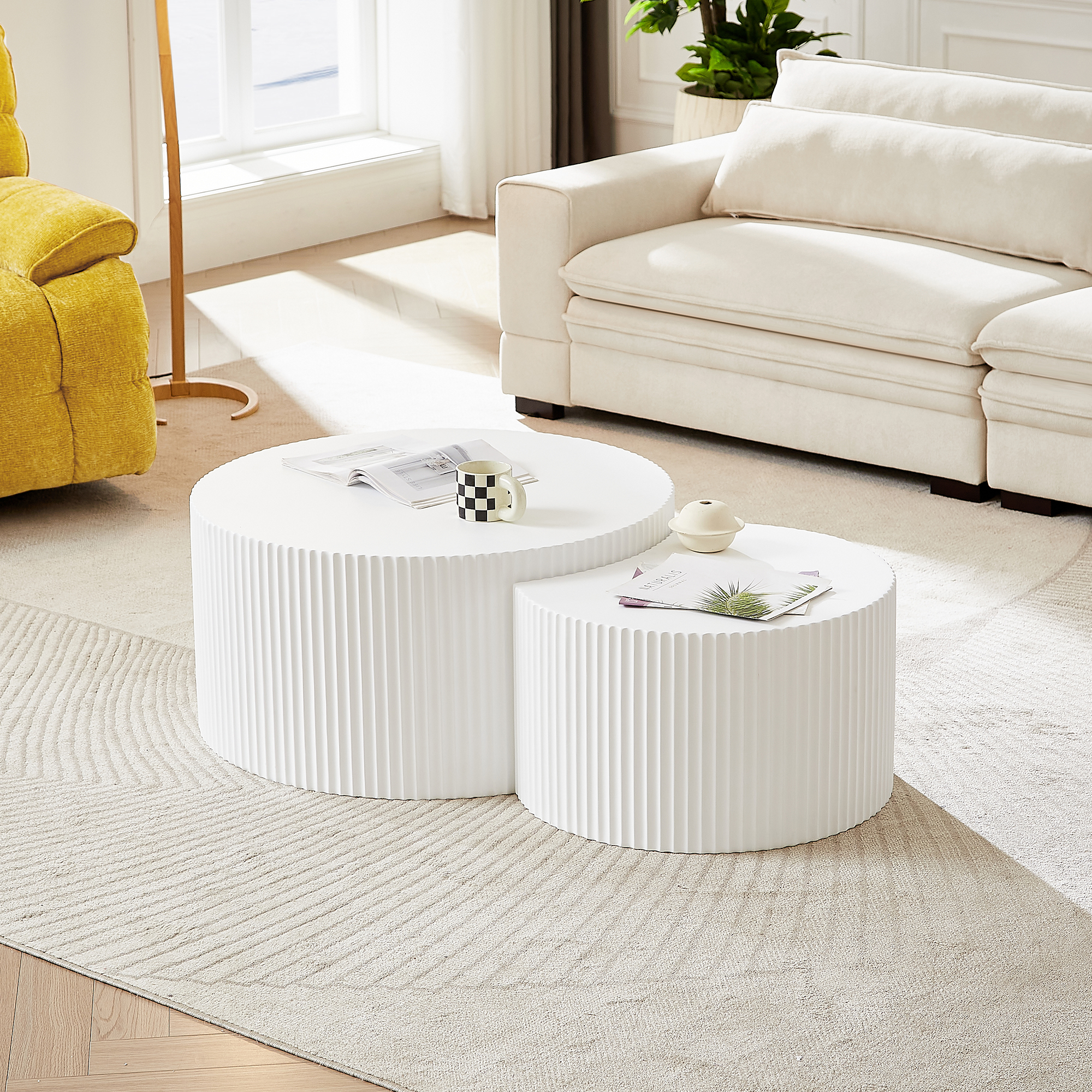 Zwei weiße Couchtische mit gerippter Textur stehen nebeneinander auf einem Teppich.