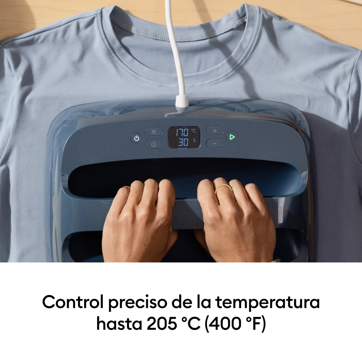 Manos operan una prensa térmica sobre camiseta azul, muestra 170°C 30s.
