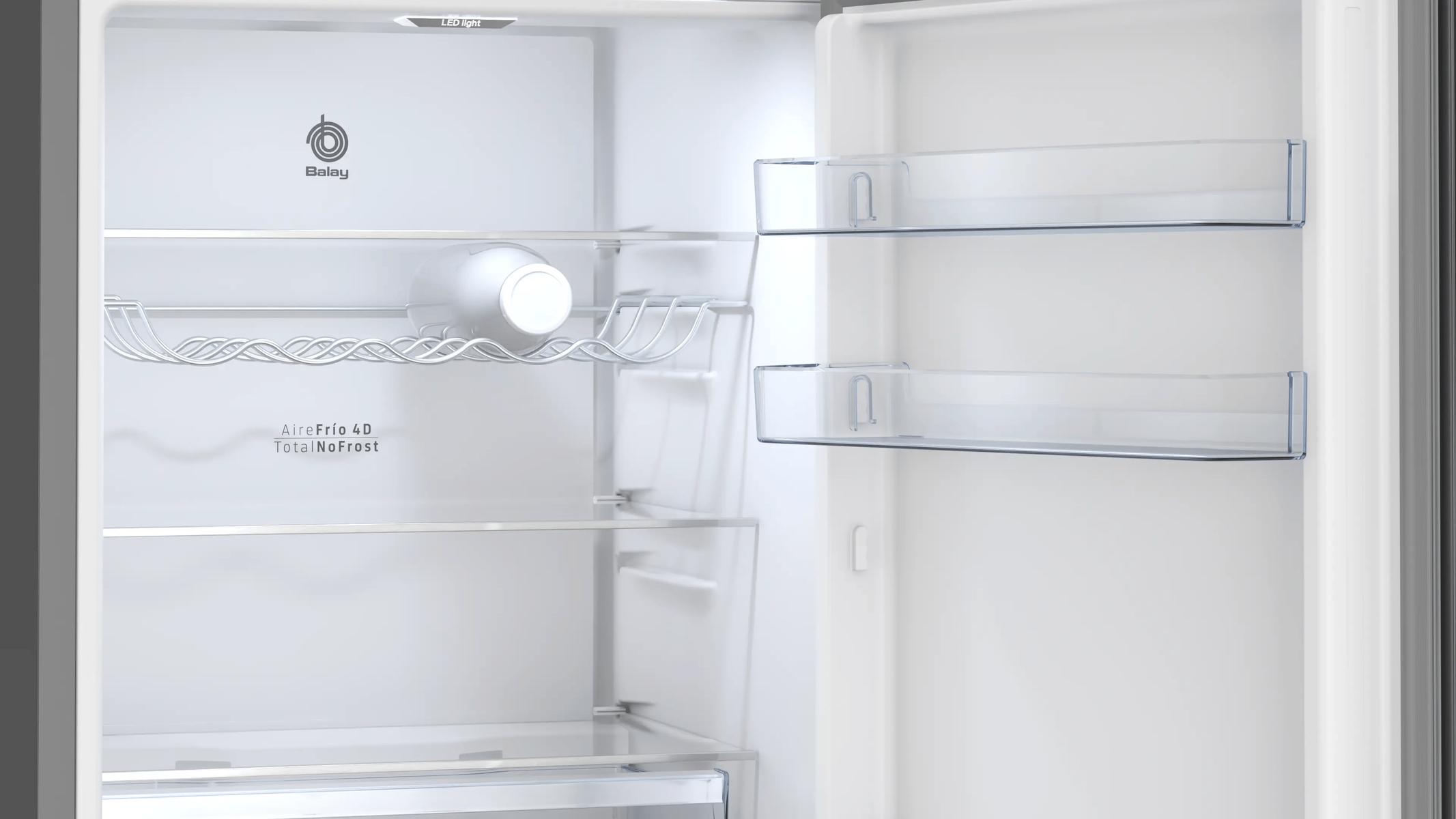 Vista interior de un refrigerador vacío con estantes y una botella.