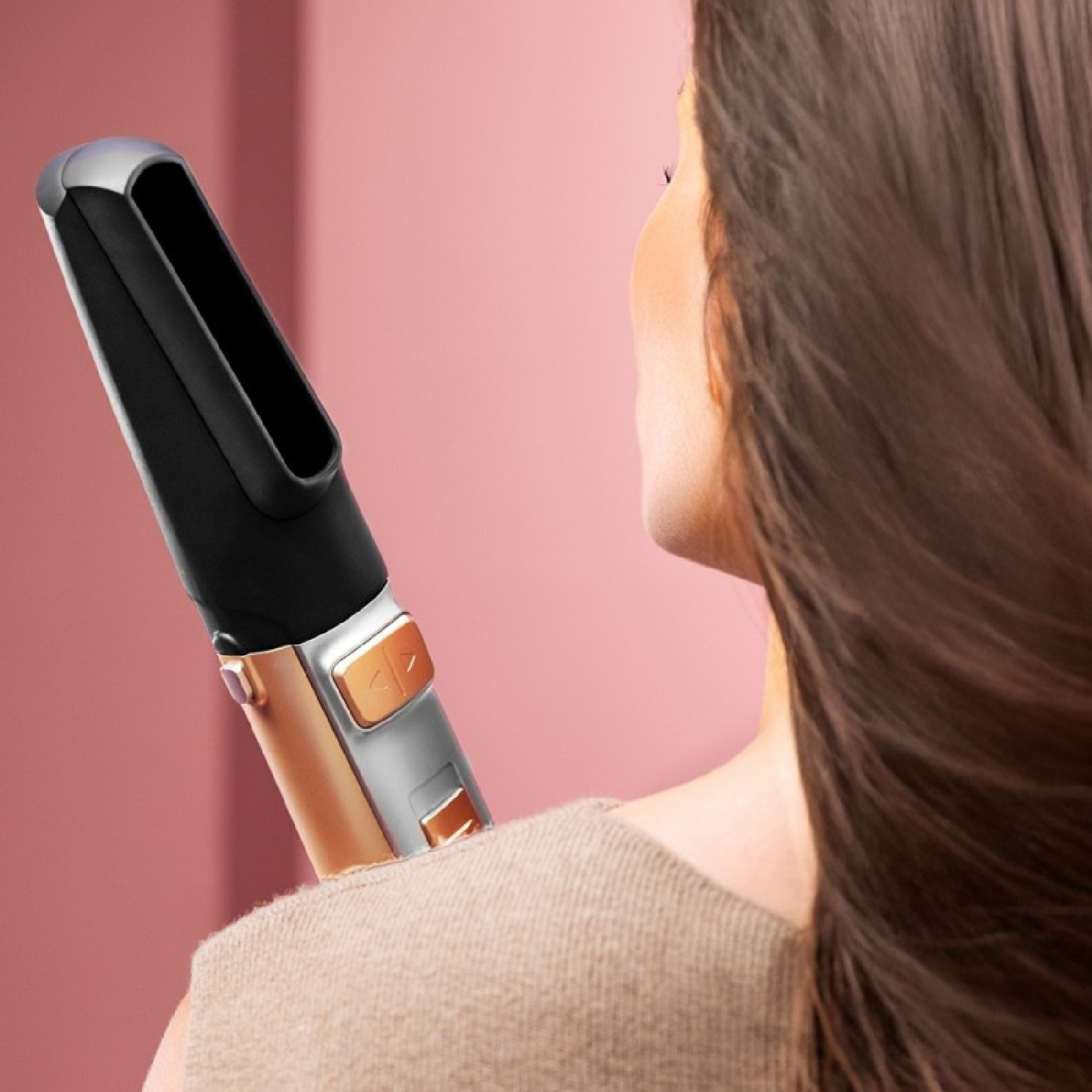 Una piastra per capelli nera con accenti dorati è posizionata sulla spalla di una donna.