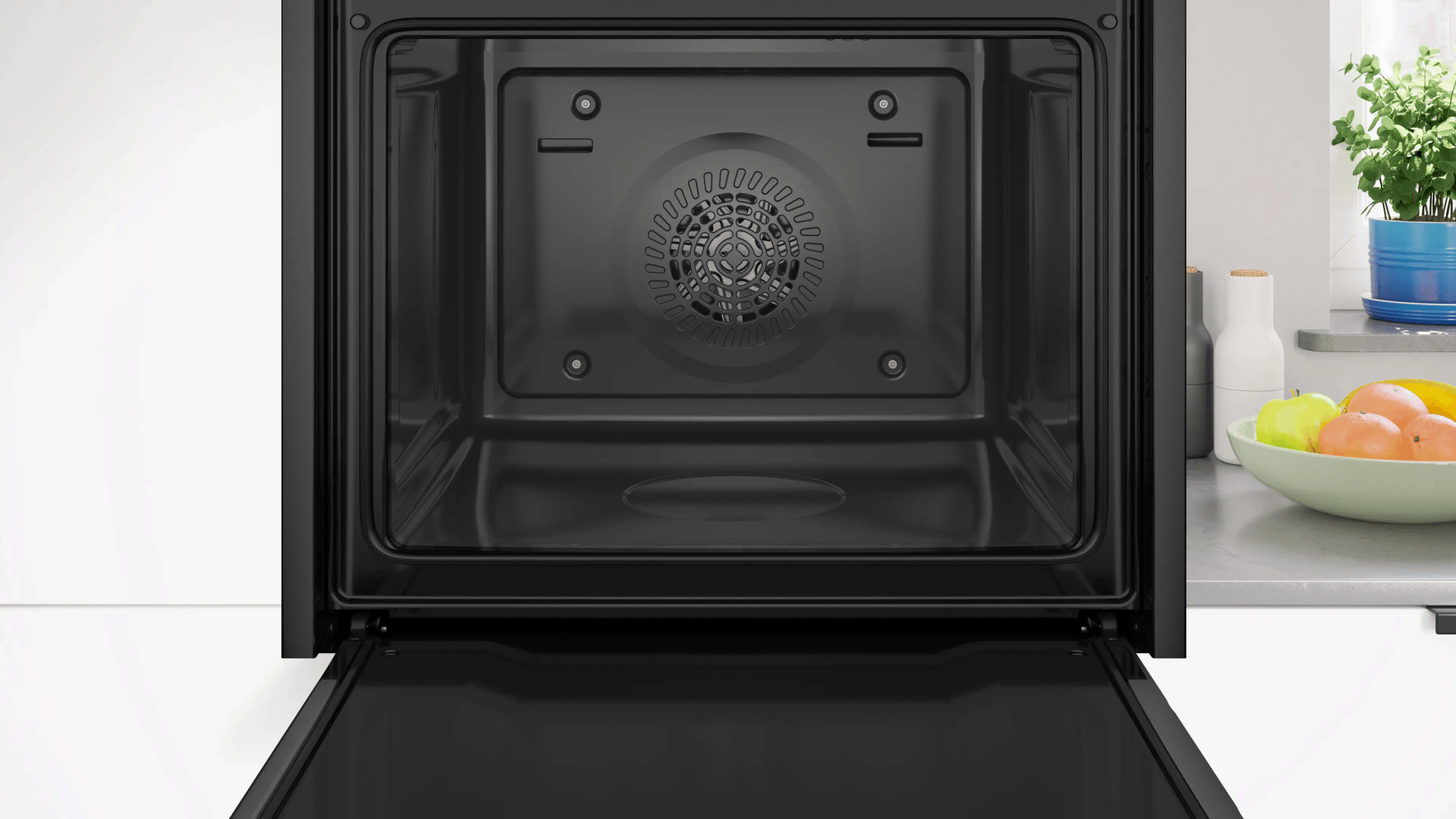 Un horno negro vacío con la puerta abierta, ventilador al fondo.