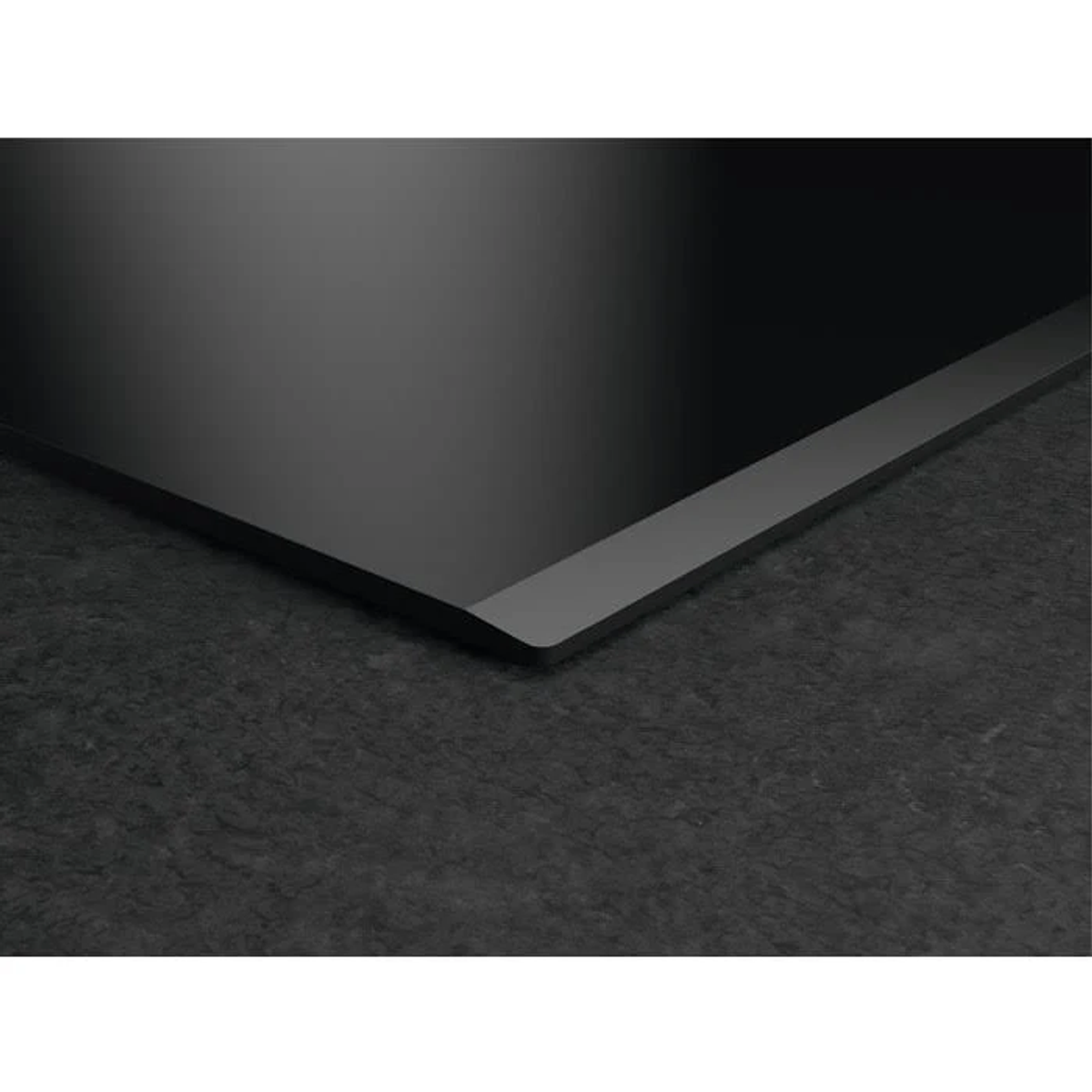 Un piano cottura a induzione nero con base grigio scuro testurizzata. Design minimalista.