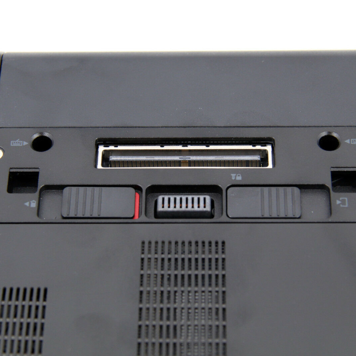 Nahaufnahme eines schwarzen Laptop-Anschlussfelds mit Docking-Port, Schiebereglern und Lüftungsschlitzen.