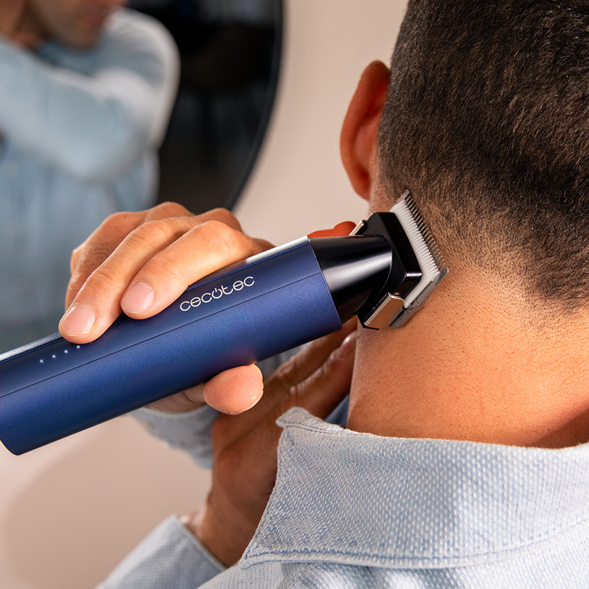 Mann trimmt seinen Nacken mit einem blauen Haarschneider, der CECotec-Marke.