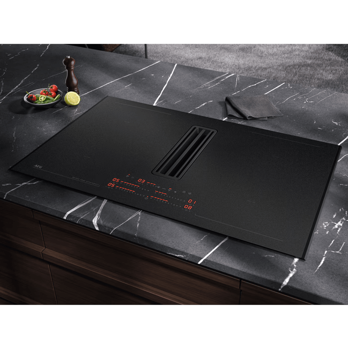 Piano cottura a induzione nero con ventilazione integrata, display digitale rosso e piano in marmo.