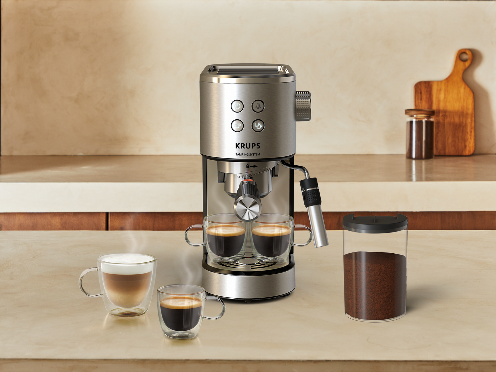 Macchina da caffè argento con due tazze di espresso e un cappuccino accanto.
