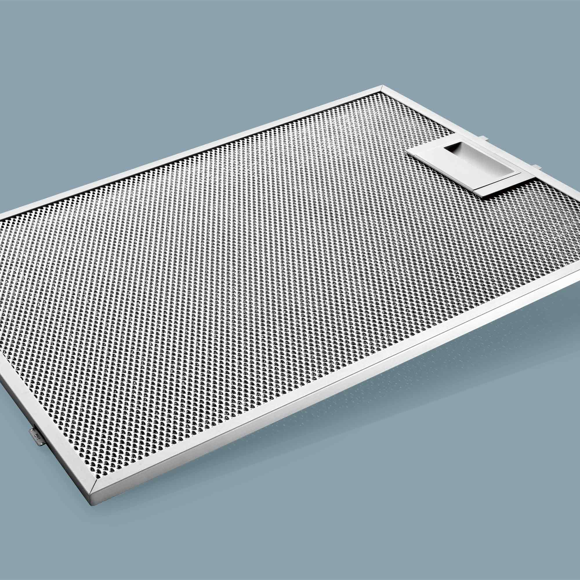 Metallfilter mit feinen Löchern und einem Griffbereich auf grauem Hintergrund.