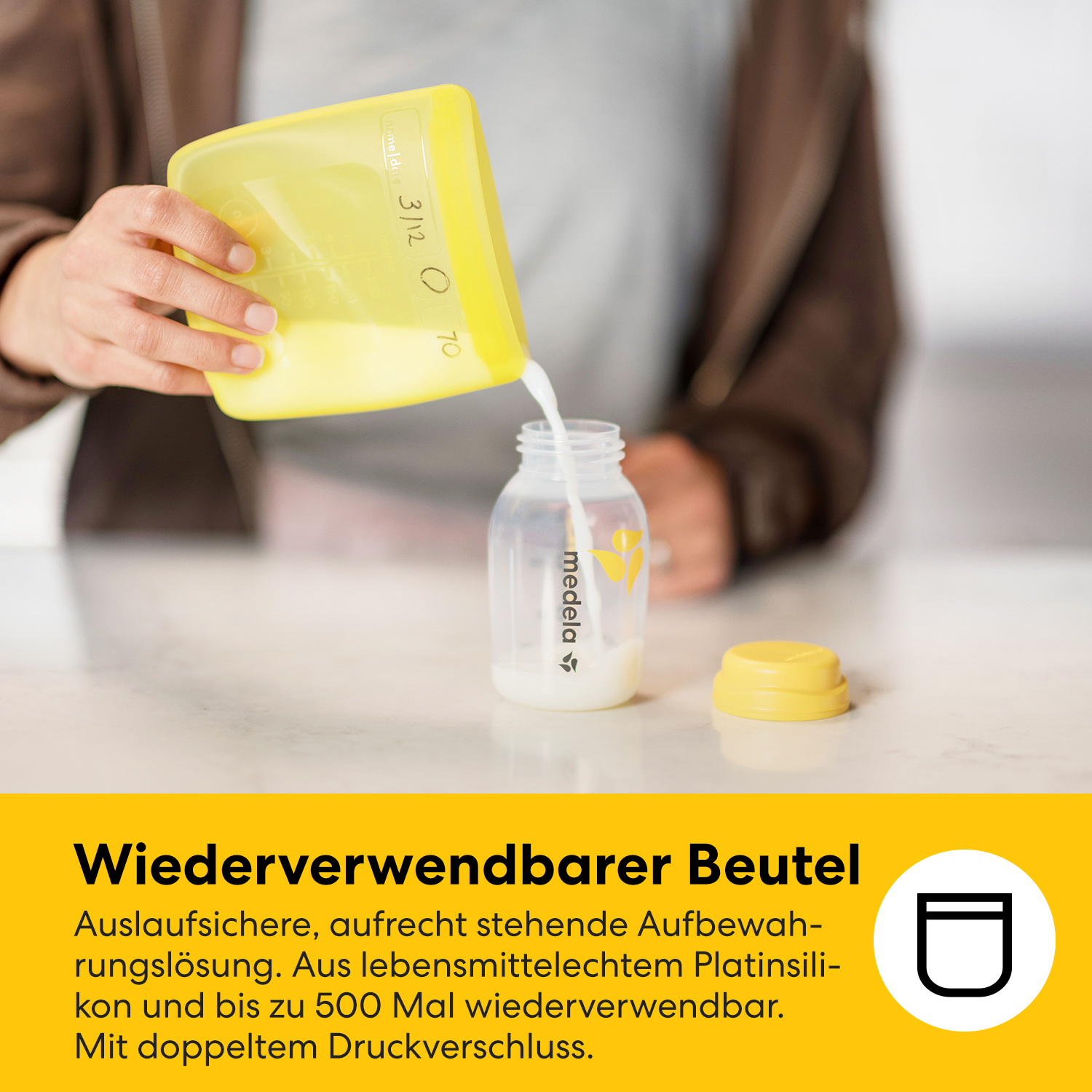 Eine gelbe Beutel gießt Flüssigkeit in eine Medela-Flasche.