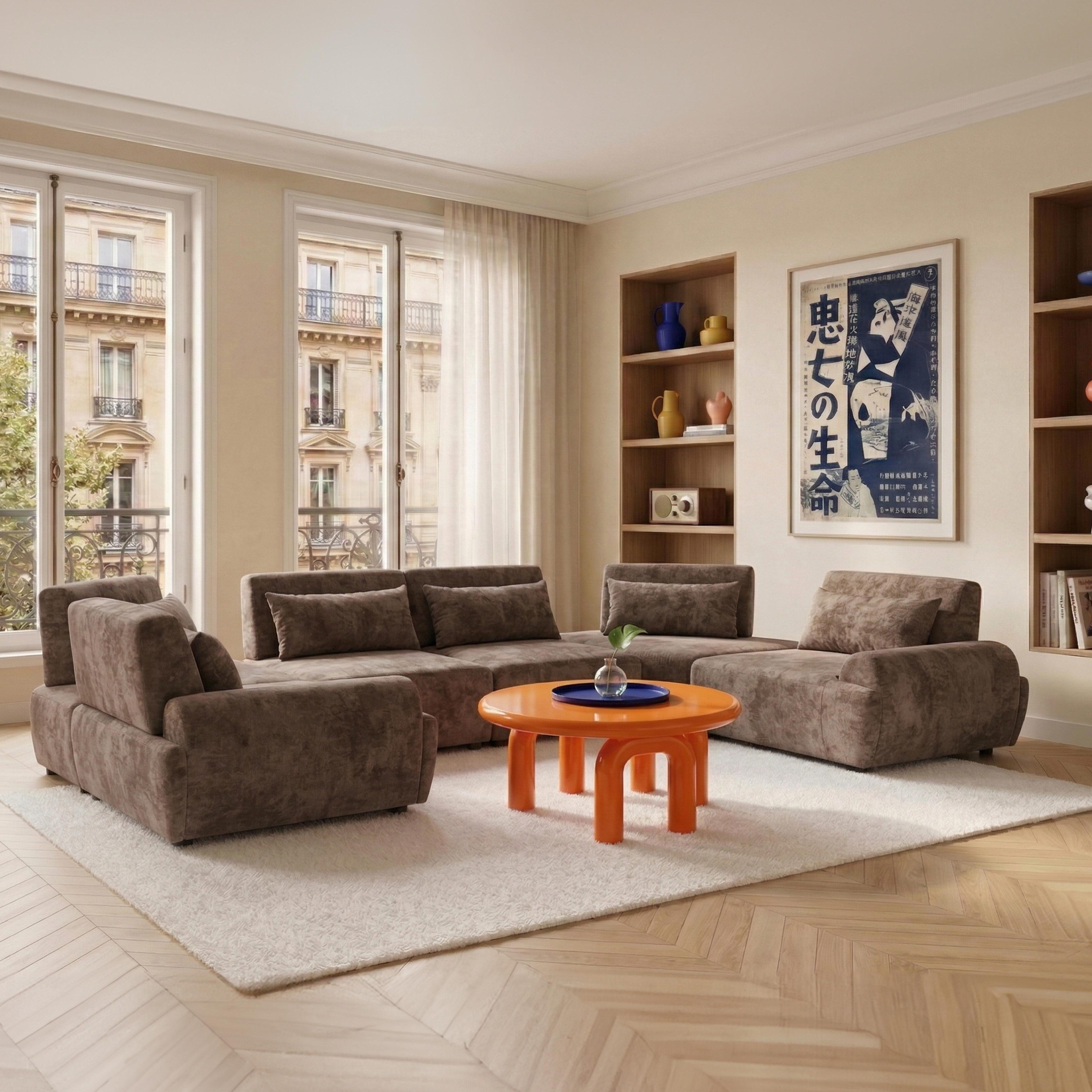 Ein Wohnzimmer mit braunen Sofas, einem orangen Tisch und einem Poster an der Wand.