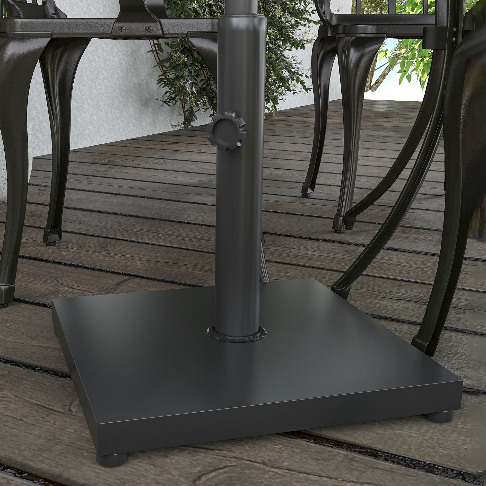 Base de sombrilla negra sobre cubierta de madera con patas de mesa y plantas.