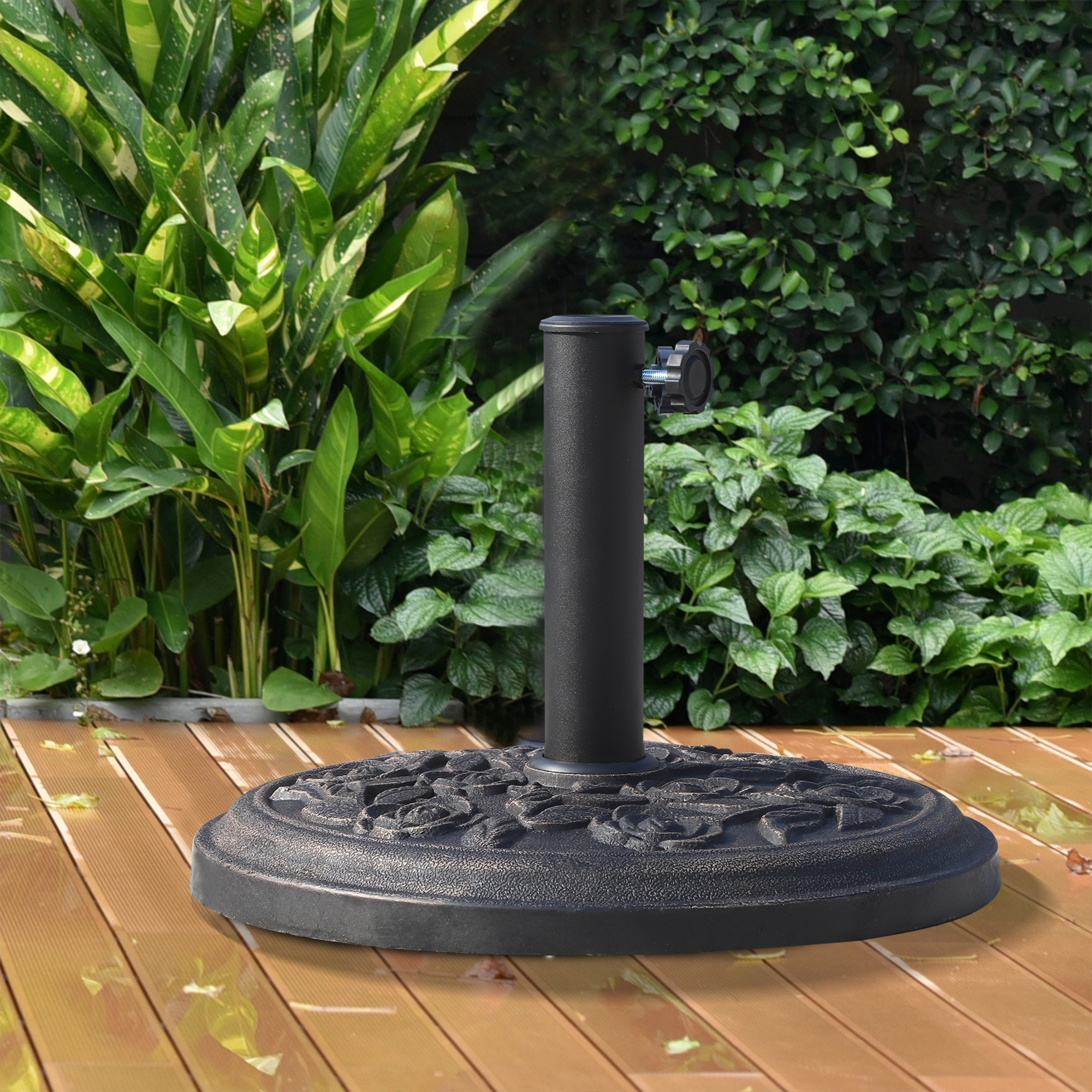 Un soporte de sombrilla negro con estampado floral sobre una terraza de madera con plantas.