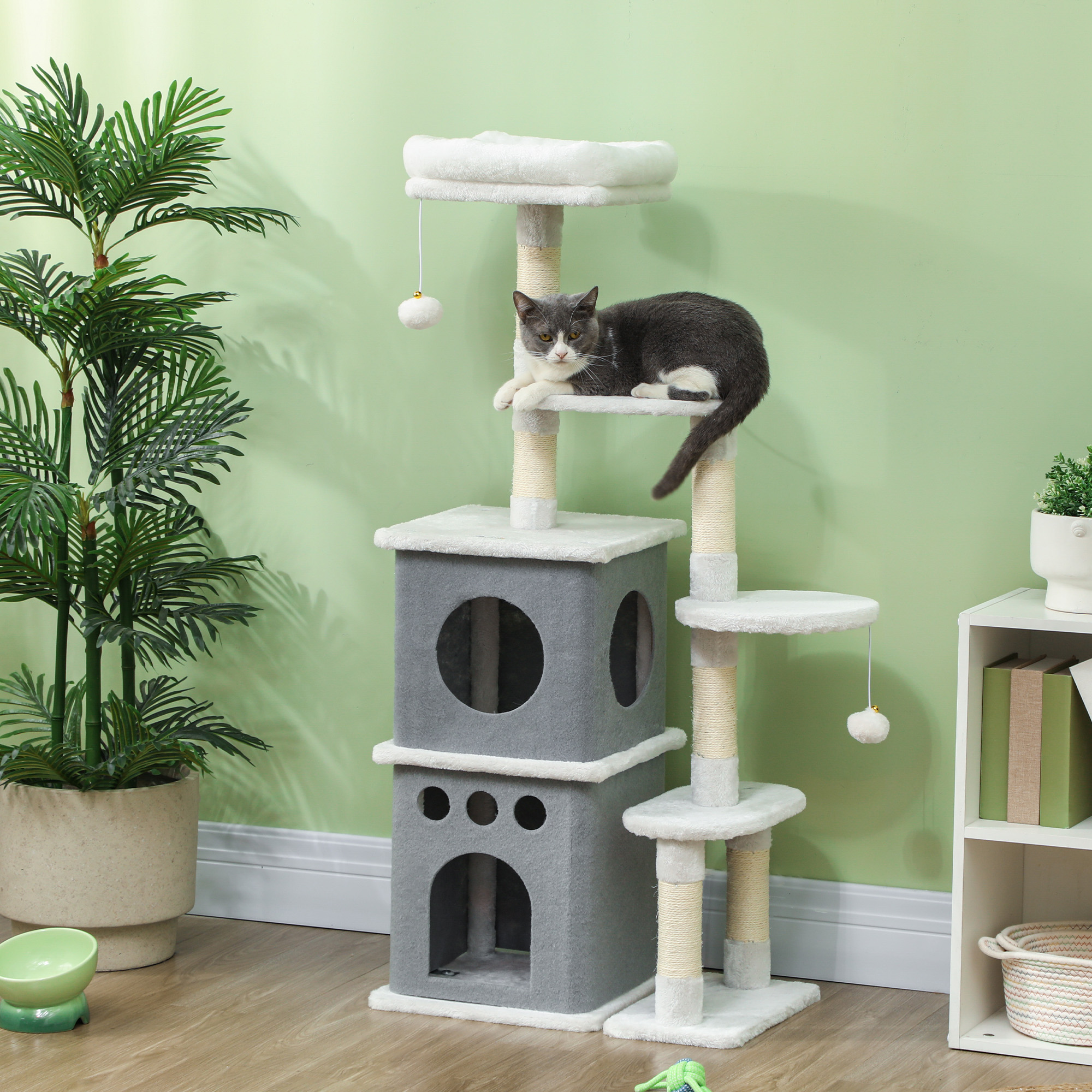 Un gato descansa en un árbol rascador multinivel con juguetes.