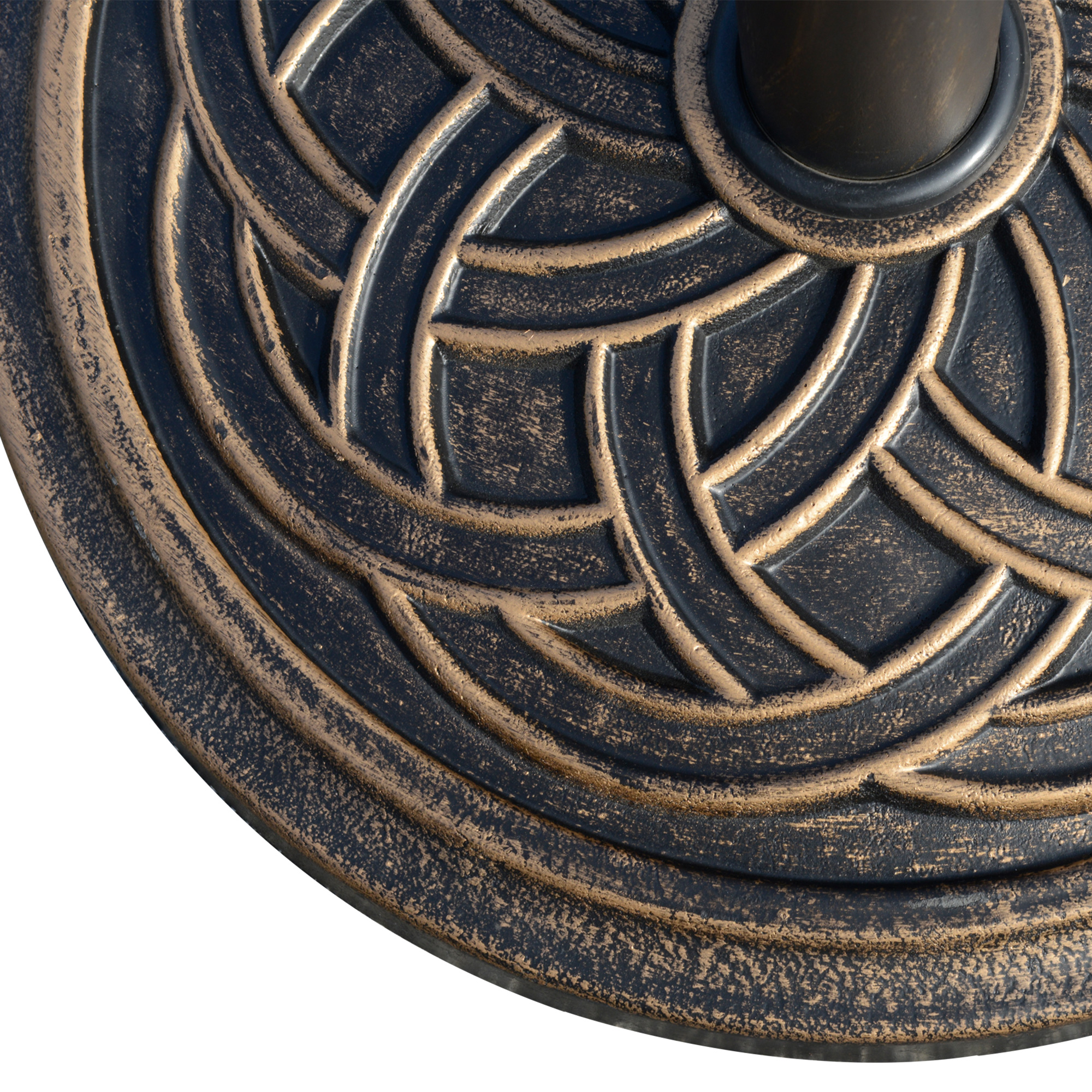 Primer plano de una base de metal oscura con diseño de patrón de bronce.