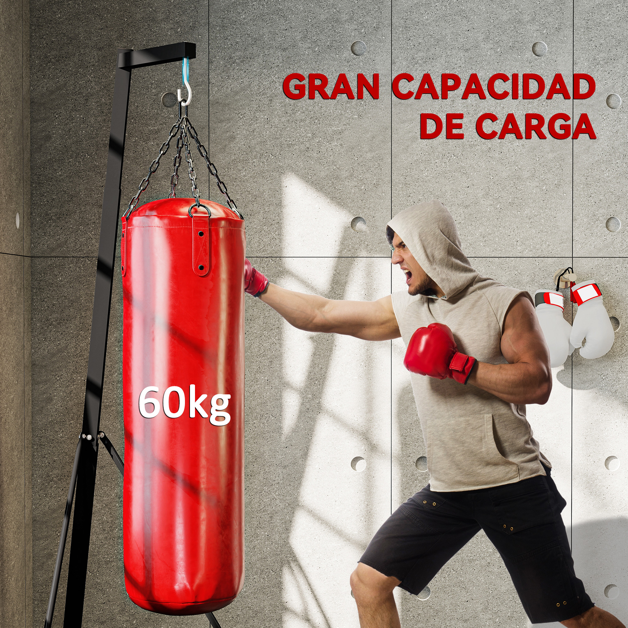 Un hombre con capucha golpea un saco de boxeo rojo de 60 kg. Guantes cuelgan cerca.