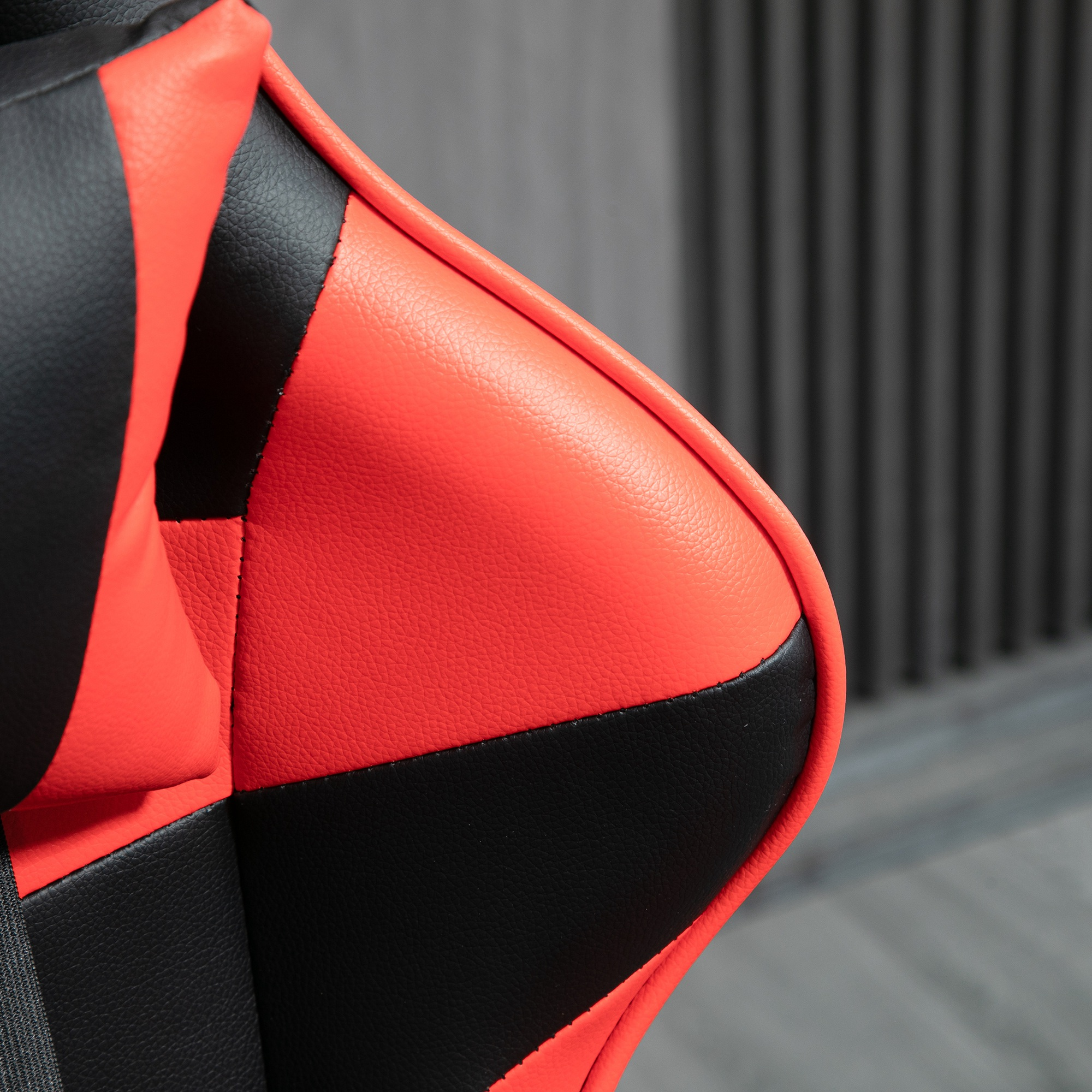 Primer plano de una silla gamer roja y negra de cuero texturizado.