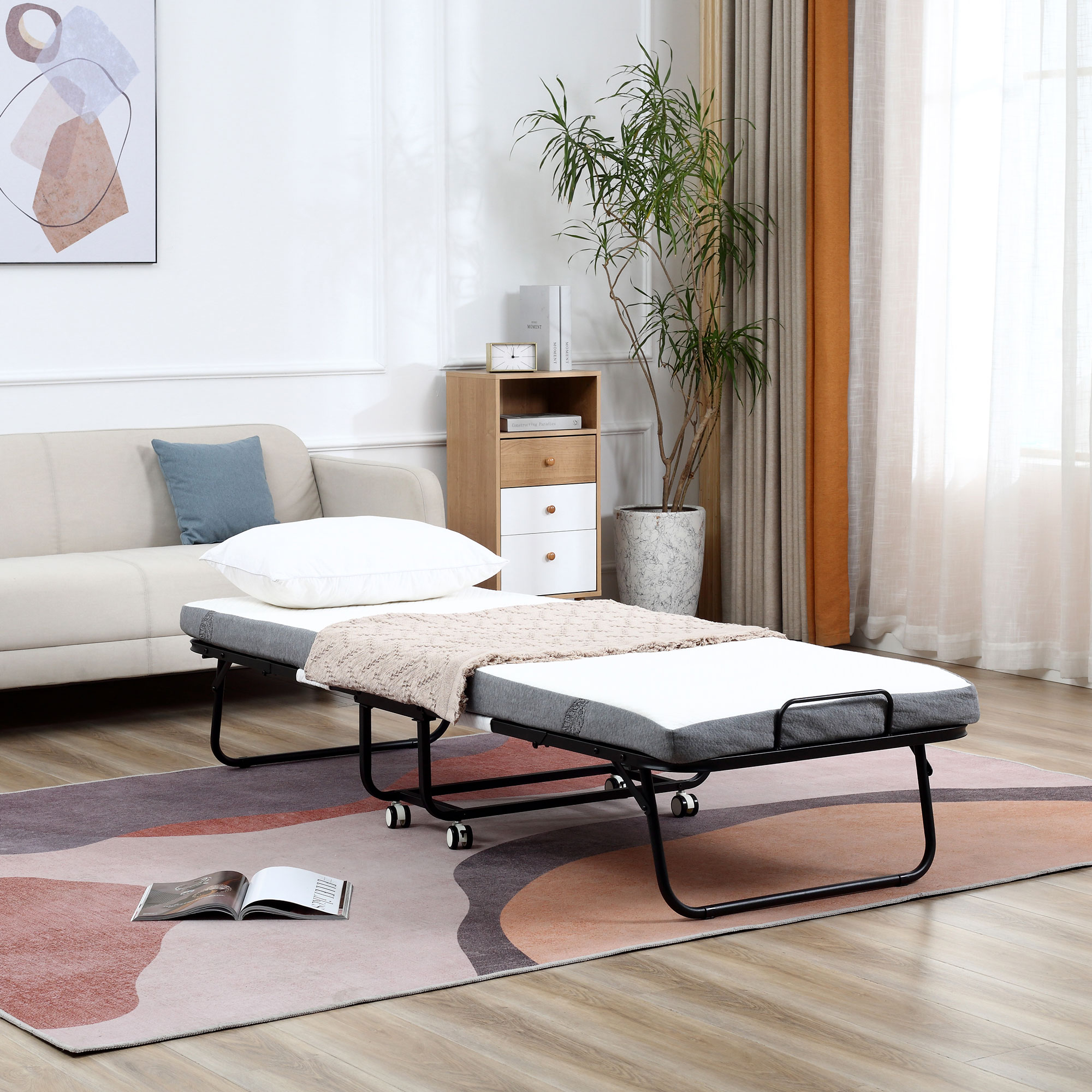 Una cama plegable con ruedas está sobre una alfombra frente a un sofá.