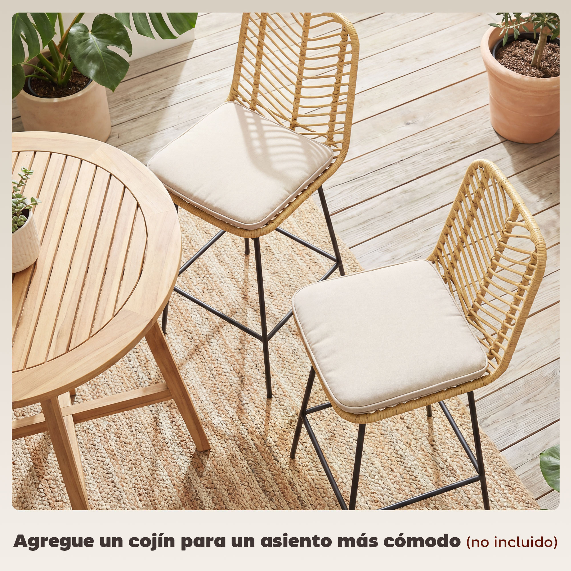 Una mesa redonda de madera y dos sillas de mimbre con cojines sobre alfombra.