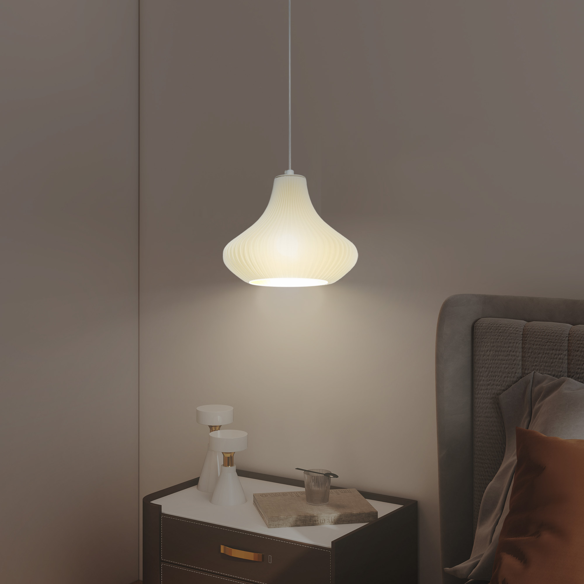 Una lámpara colgante blanca plisada sobre una mesita de noche con decoraciones.
