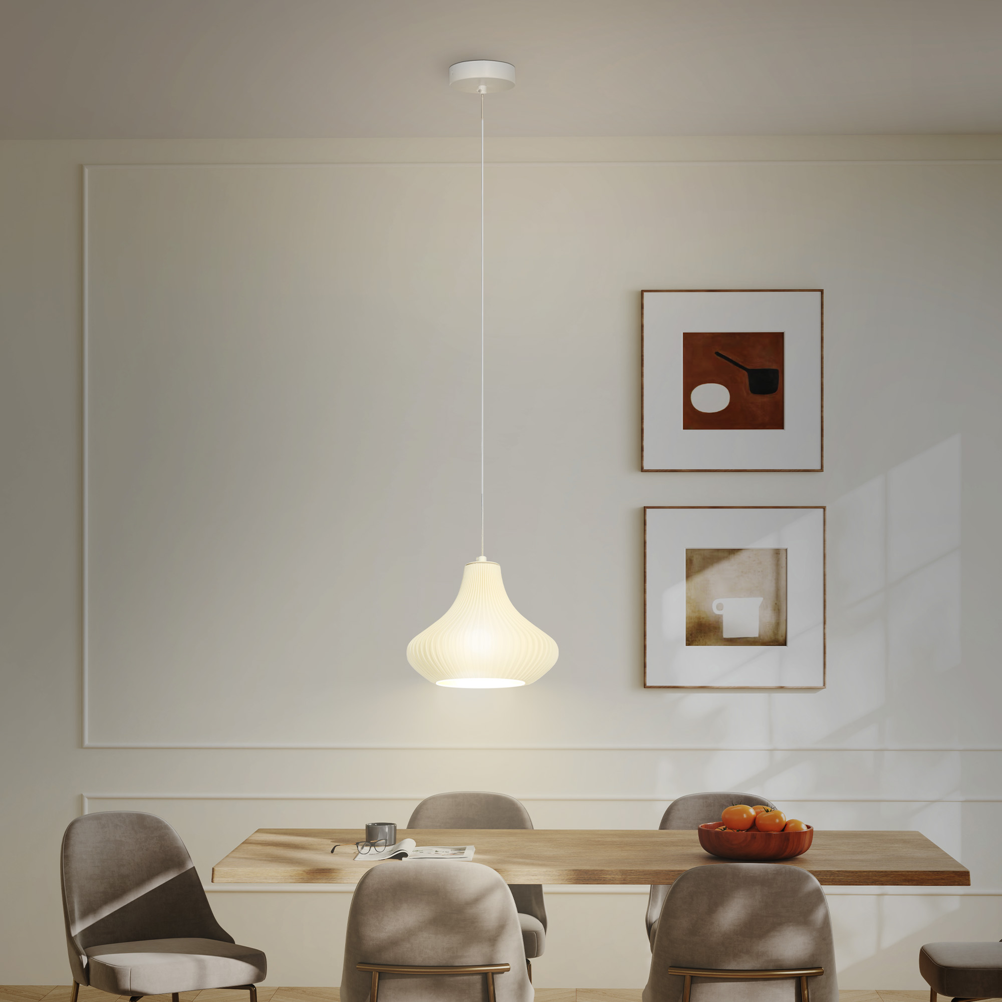 Una mesa de comedor con sillas, frutero y dos cuadros en la pared.