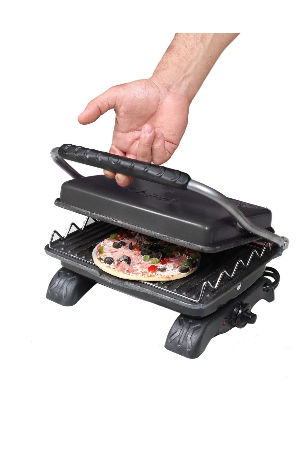 Bir el, ızgaradaki pizzayı indiren bir pizza makinesi tutuyor.