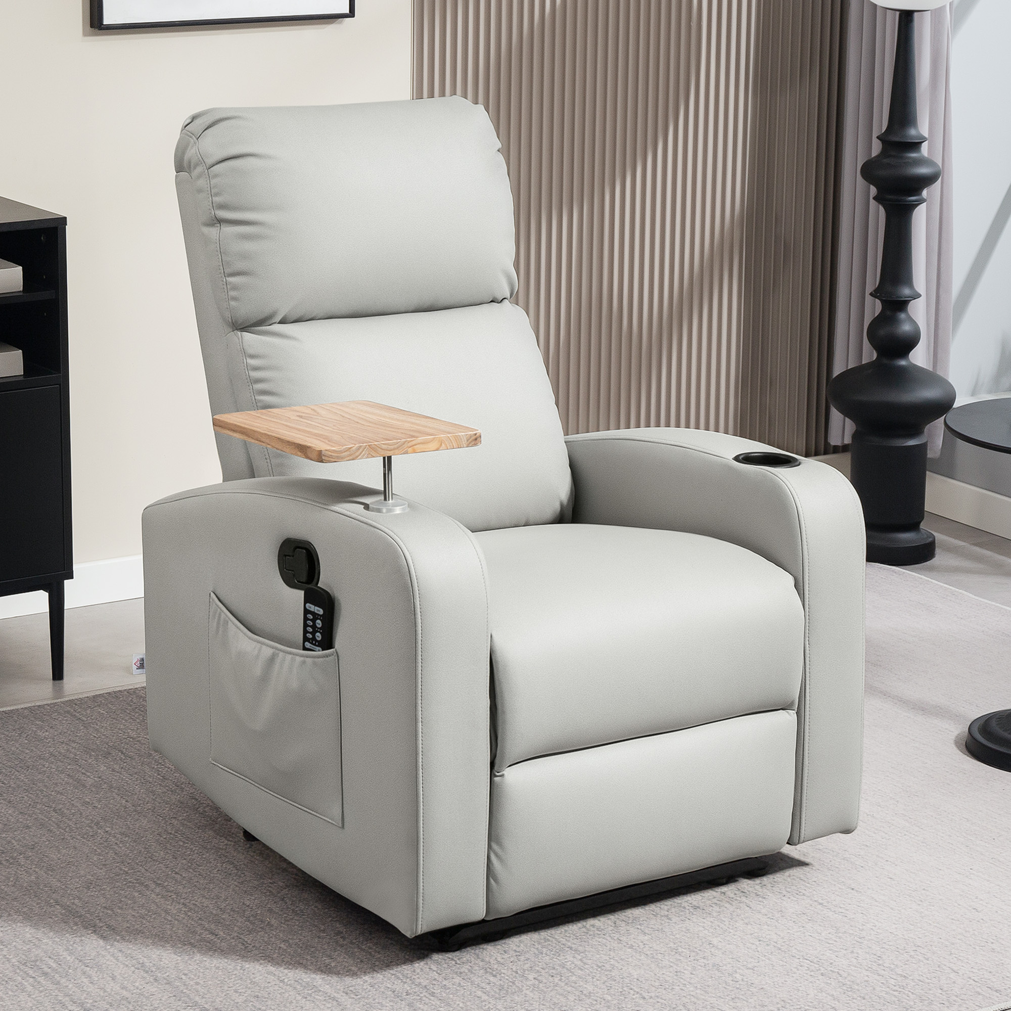 Un sillón reclinable gris claro con bandeja de madera, portavasos y control remoto.